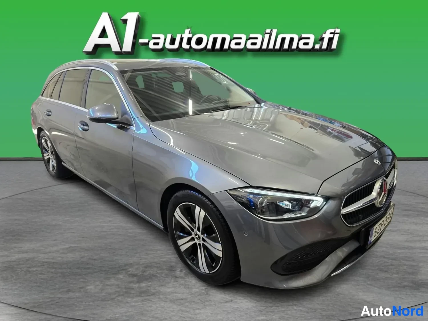 Etuviisto, nokka oikealle: Hopeanharmaa Mercedes-Benz C 220 d -farmari etukenossa oikealta, ettanäkyvissä keula ja vasen sivu.