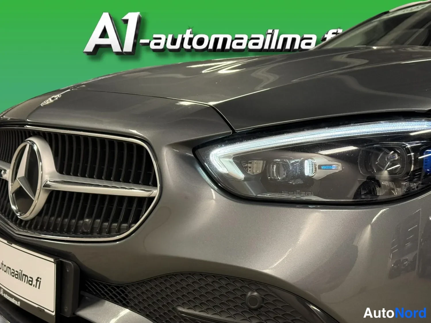 Edestä: Lähikuva konepellin reunasta ja etuvalosta: Mercedes-tähti ja grille kuvassa vasemmalla.