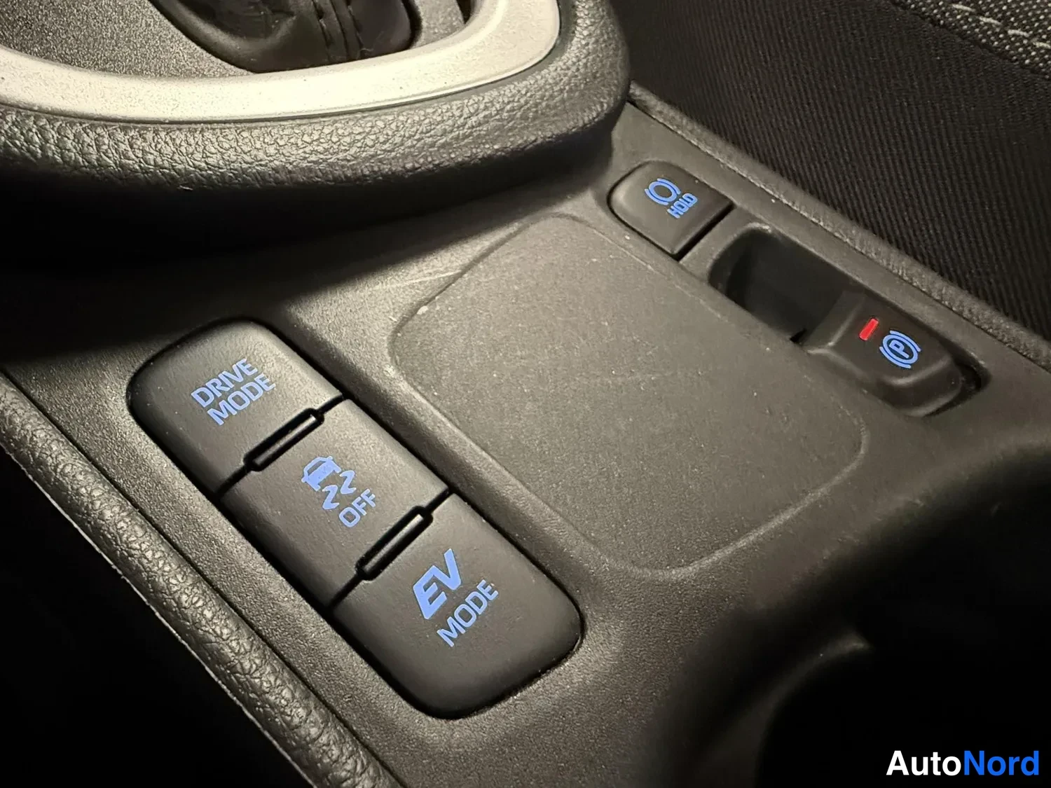 Muu: Hybridiauton ajotilakatkaisijat: DRIVE MODE, OFF ja EV MODE -napit ja vieressä elektronisen parkkijarrun napit.