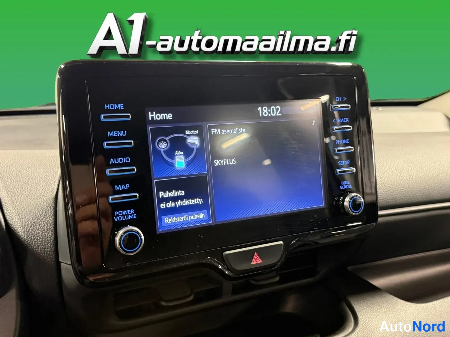 Muu: Vitrikoskevassa infotainment-näytössä Home-valikko, kello 18:02, FM-asemalista SKYPLUS, teksti 'Puhelinta ei ole yhdistetty' ja Rekiateröi puhelin -painike; ylä