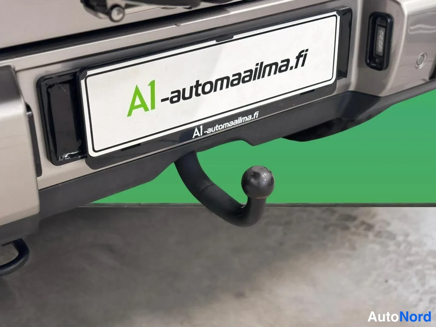Takaa: Lähikuva auton takapuskurin vetokoukusta ja rekisterikilpi-kyltistä, jossa lukee A1-automaailma.fi.