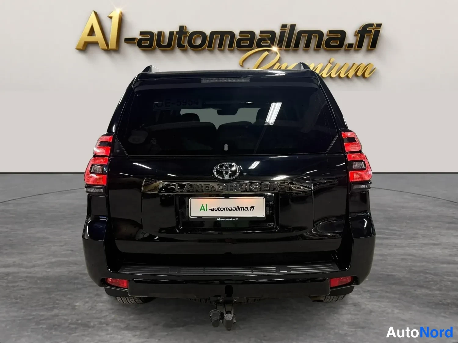 Takaa: Mustan Toyota Land Cruiserin takanäkyvissä näkyvät takavalot, Toyota-merkki ja Land Cruiser -teksti.