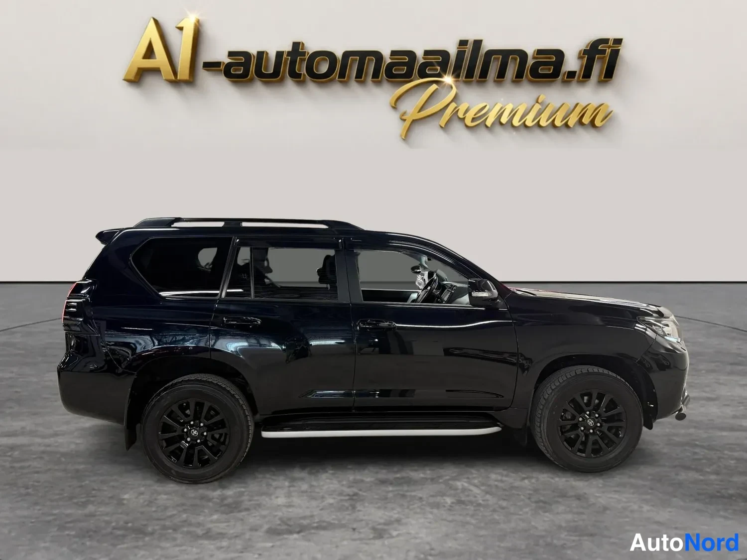 Etuviisto, nokka oikealle: Musta Toyota Land Cruiser kokonaan sivulta oikeaan nokka oikealla, tummat vanteet ja kromilista.