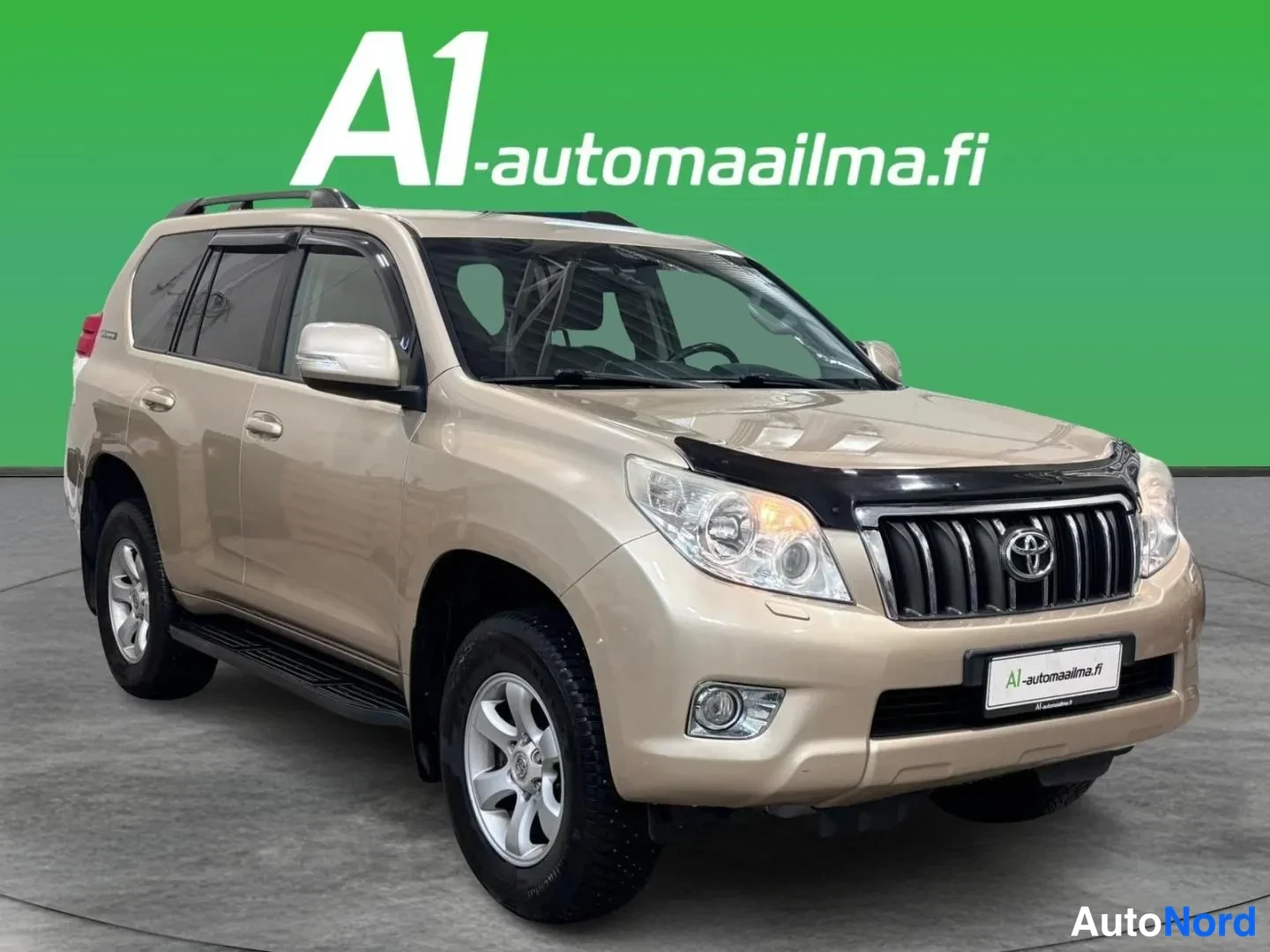 Etuviisto, nokka oikealle: Beige Toyota Land Cruiser kolmivartalokulmasta edestä oikealta, keula ja molemmat sivut näkyvät studiopohjalla.
