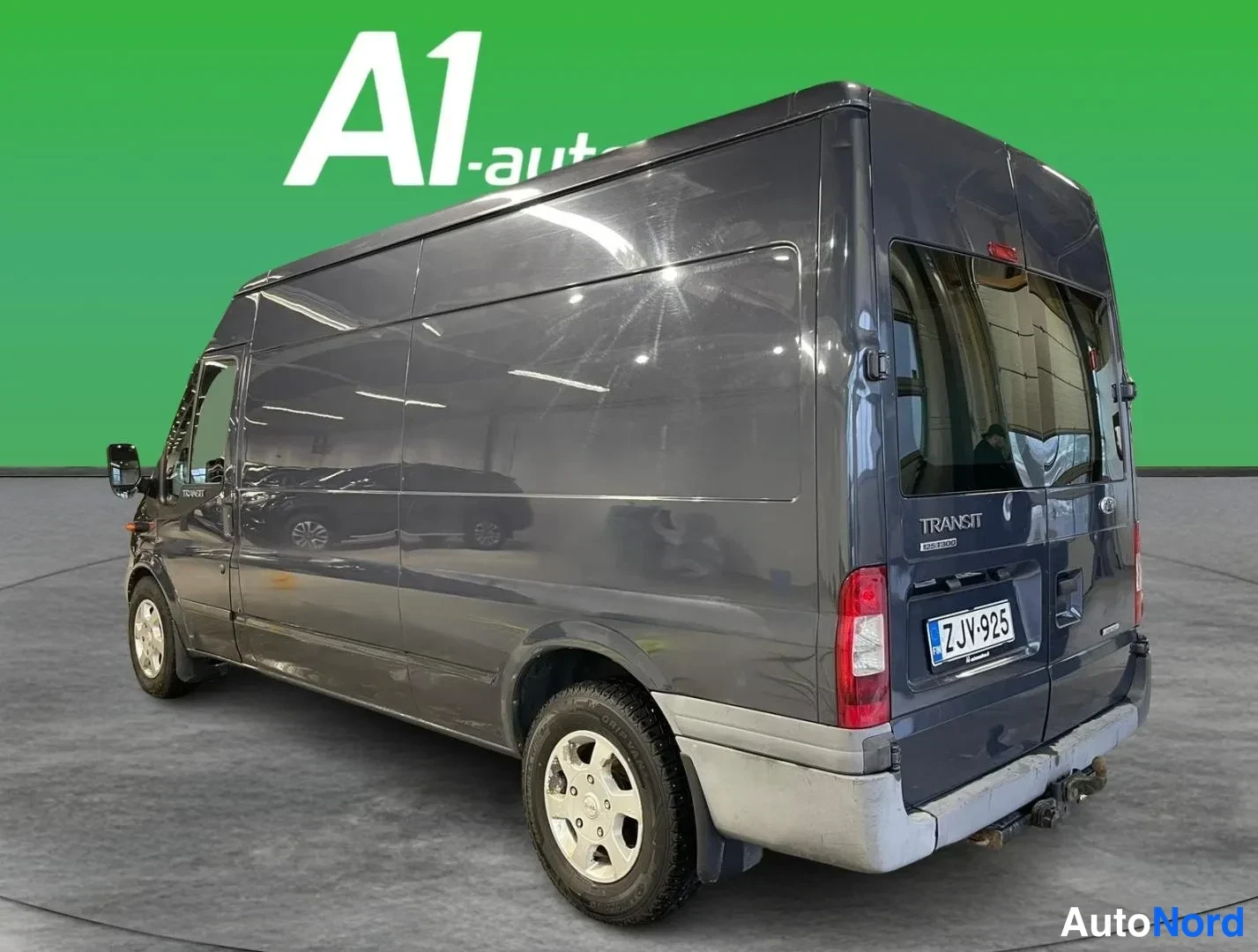 Takaviisto: Ford Transit -pakettiauton takaosan kolmeneljäsosa-näkymä vasemmalta, tummanharmaa kori, rekisteritunnus