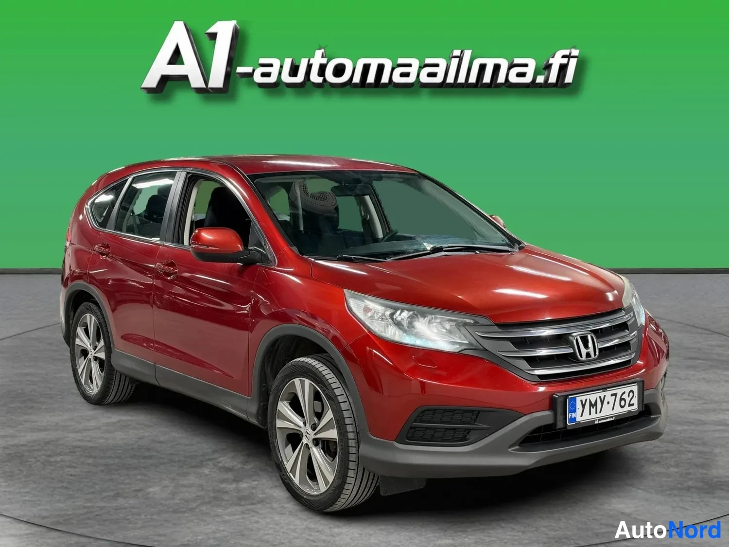 Etuviisto, nokka oikealle: Punainen Honda CR-V etuokoliskuva, keula ja vasen kylki näkyvät, rekisterikilpi.