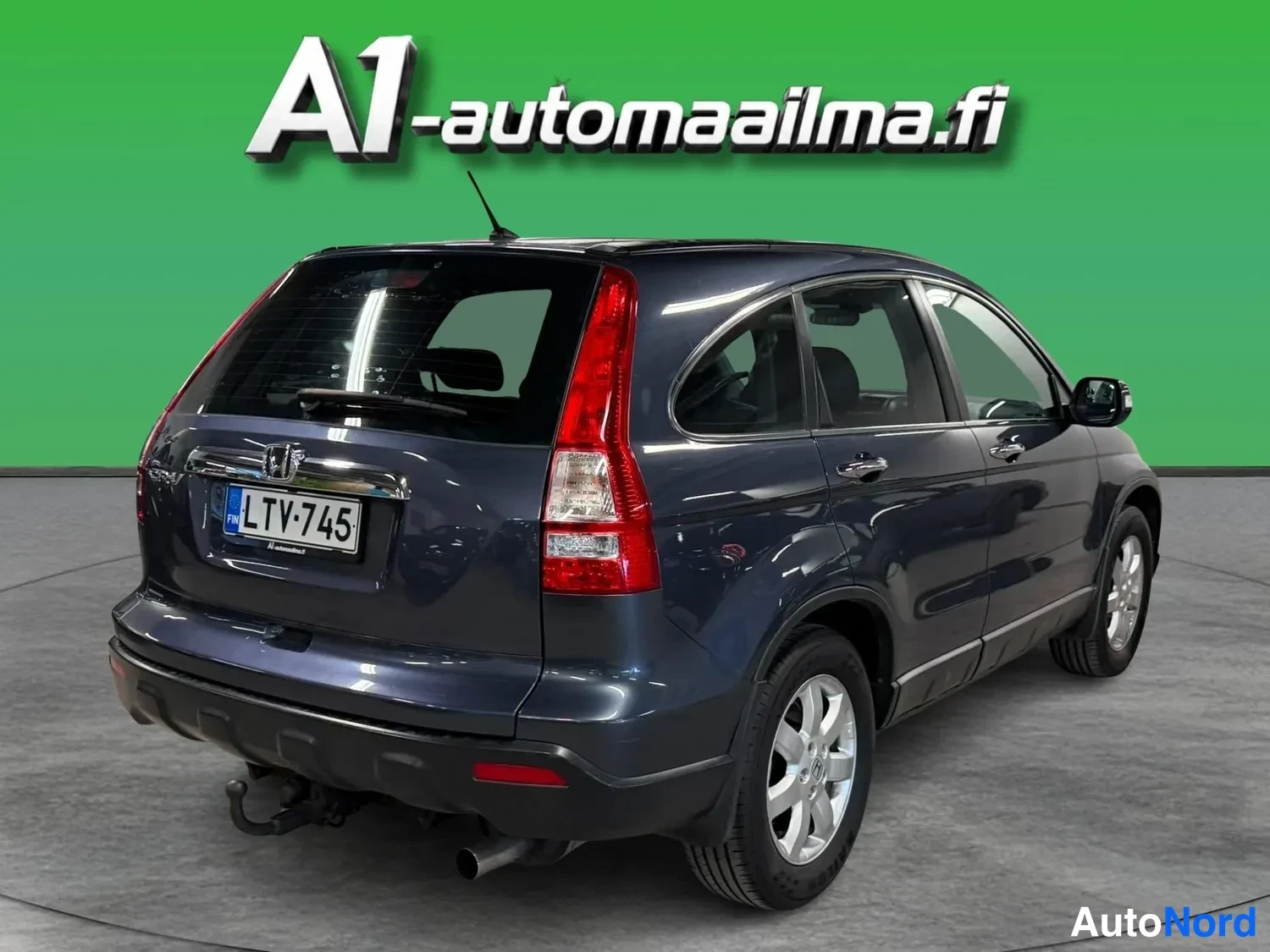 Takaviisto: Honda CR-V takaviisto vasemmalta, tummansininen, rekisteritunnus, perävaunukytkin näkyy takapuskurin alla.