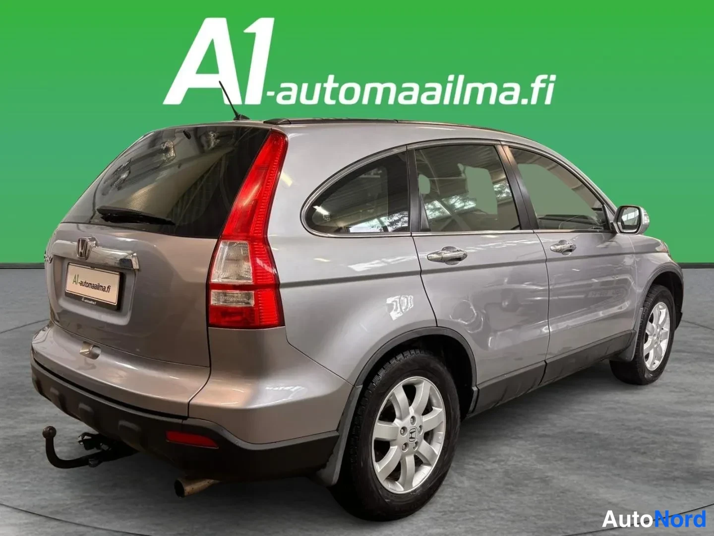 Takaviisto: Honda CR-V takaviistosta oikealta; hopeanharmaa kori, konepellin takana takapää vasemmalla, viides ovi ja tavaratila auki kuvakulmassa, kylki ja renkaat näkyvis