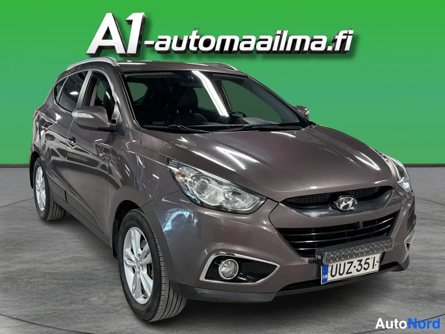 Etuviisto, nokka oikealle: Hyundai ix35 etuviistosta oikealta, ruskeanharmaa kori, rekisteri.