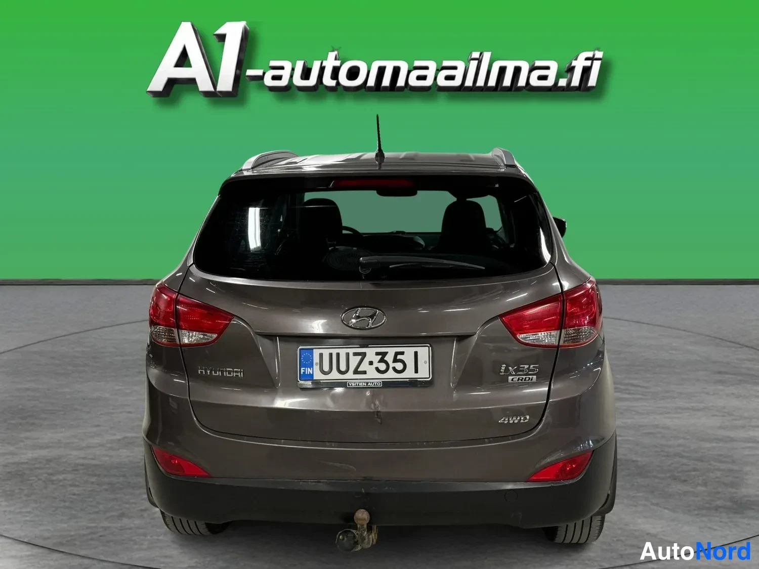 Takaa: Hyundai ix35:tä takaa: tummanharmaa koripaneeli, punaiset takavalot, rekisterikilpi ja Ix35 CRDi -merkinnät.