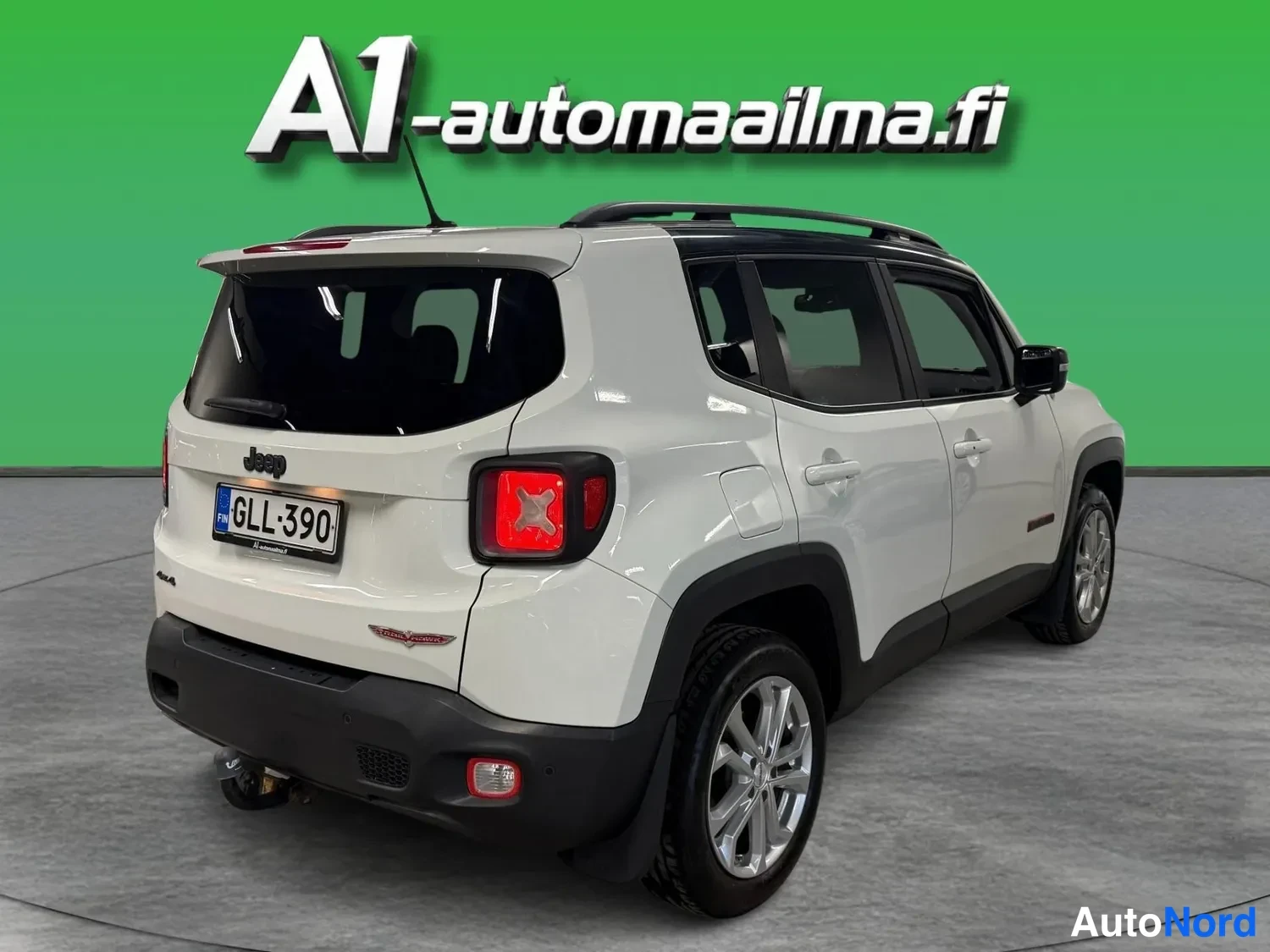 Takaviisto: Valkoinen Jeep Renegade takavasemmalta nähtynä, rekisteritunnus, laatikkomainen takaosa ja tummat kynnykset.