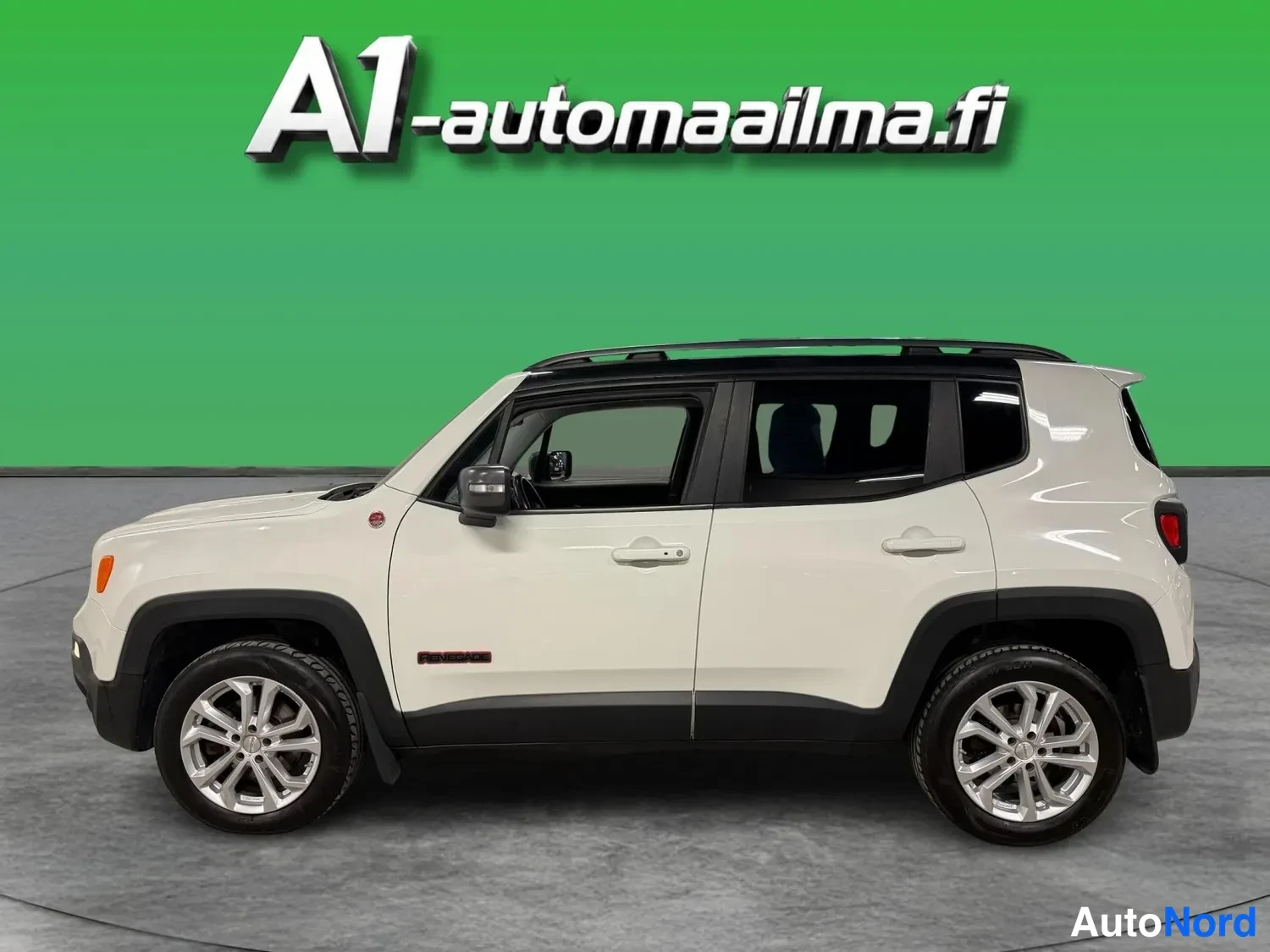 Sivulta: Valkoinen Jeep Renegade kyljestä nähtynä, tummat kynnykset, hopeiset vanteet ja tumma katotunnus.