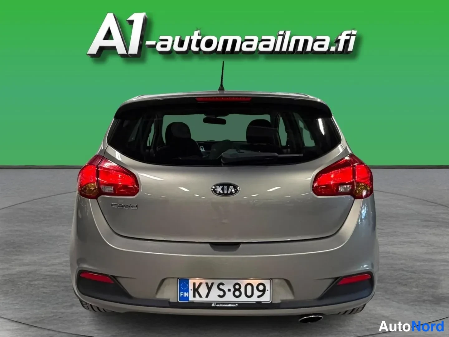 Takaa: Auton takaosa suoraan takaa: Kia-merkki ja cee'd-teksti takaluukussa, punaiset takavalot, rekisterikilpi.