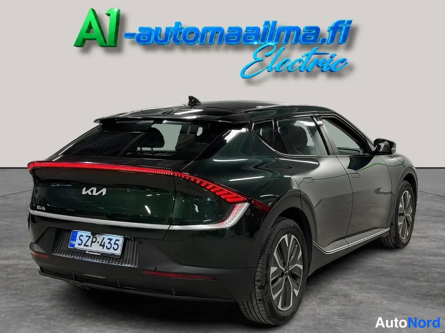 Takaviisto: Kia EV6 takaa viistosti oikealta; tummanvihreä kori, takavalotanko ja kevytmetallivanteet näkyvät.