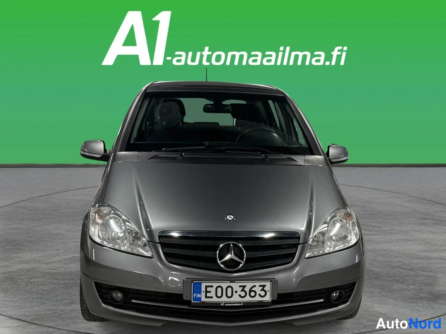 Edestä: Harmaa Mercedes-Benz A -sarja suoraan edestäpäin kuvattuna, rekisterikilpi E00-363.
