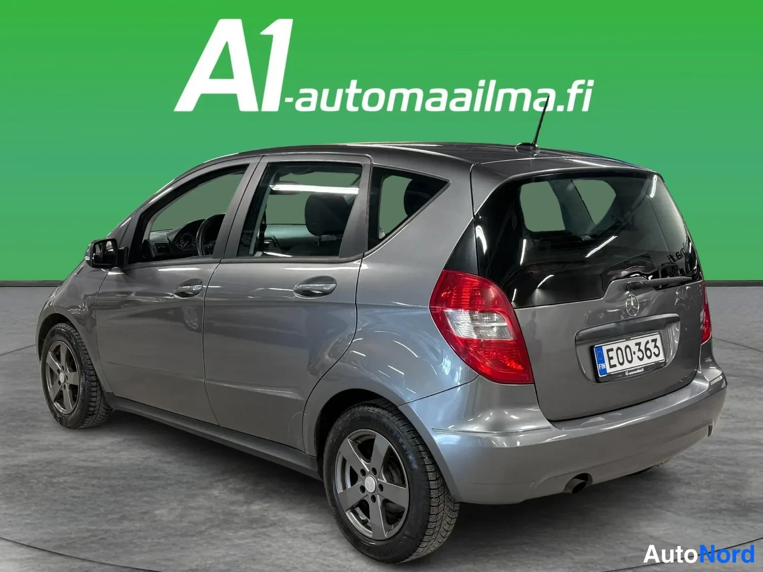 Takaviisto: Mercedes-Benz A-sarjan hatchback kolmeneljännes-takakuvassa: harmaa kori, tummat ikkunat, viisiovinen korirakenne ja hopeavanteiset renkaat.