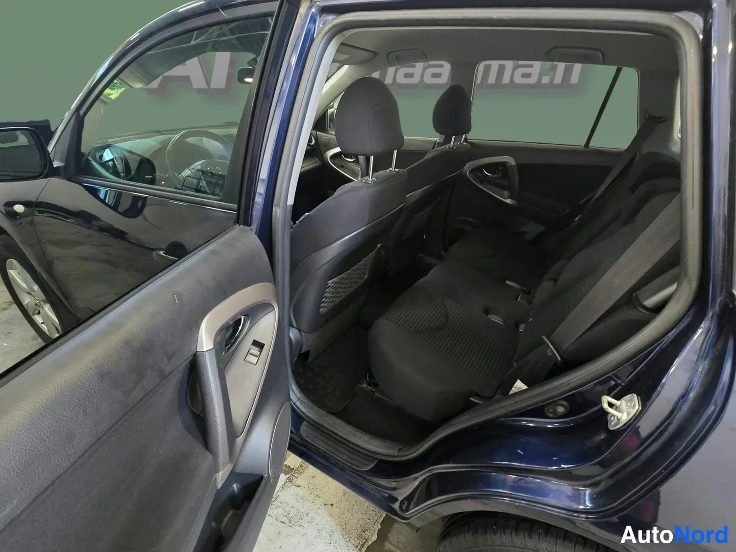 Muu: Toyota RAV4:n takapenkkien istuimet ja kolme napanukea näkyvät takaoven kautta.
