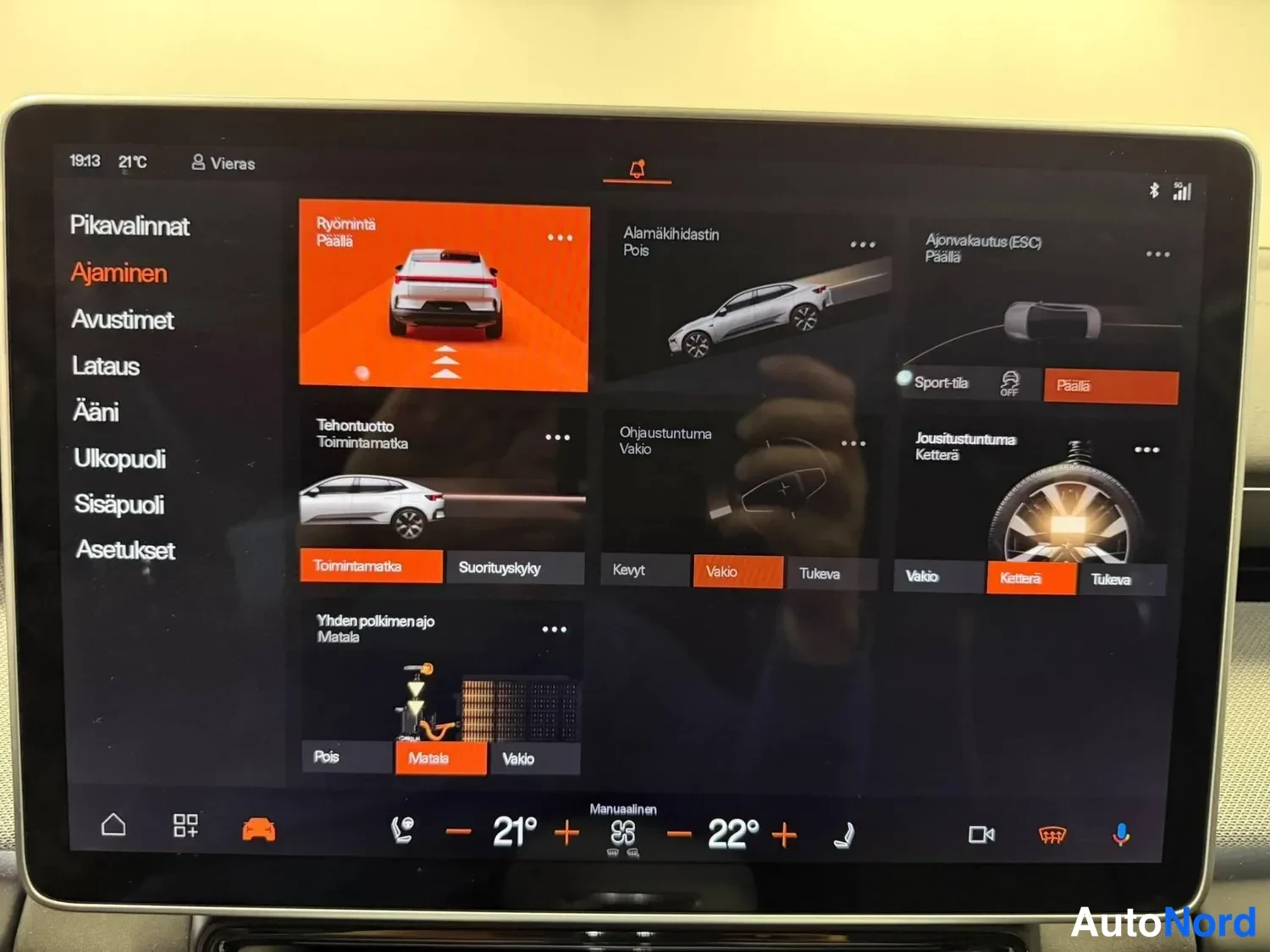 Muu: Auton infotainment-näytön Ajaminen-valikko, jossa asetuksia kuten Rööminä pois päältä, Tehontuotto, Ohjaustuntuma ja Jousitustuntuma, valittuna muun muassa Vaki