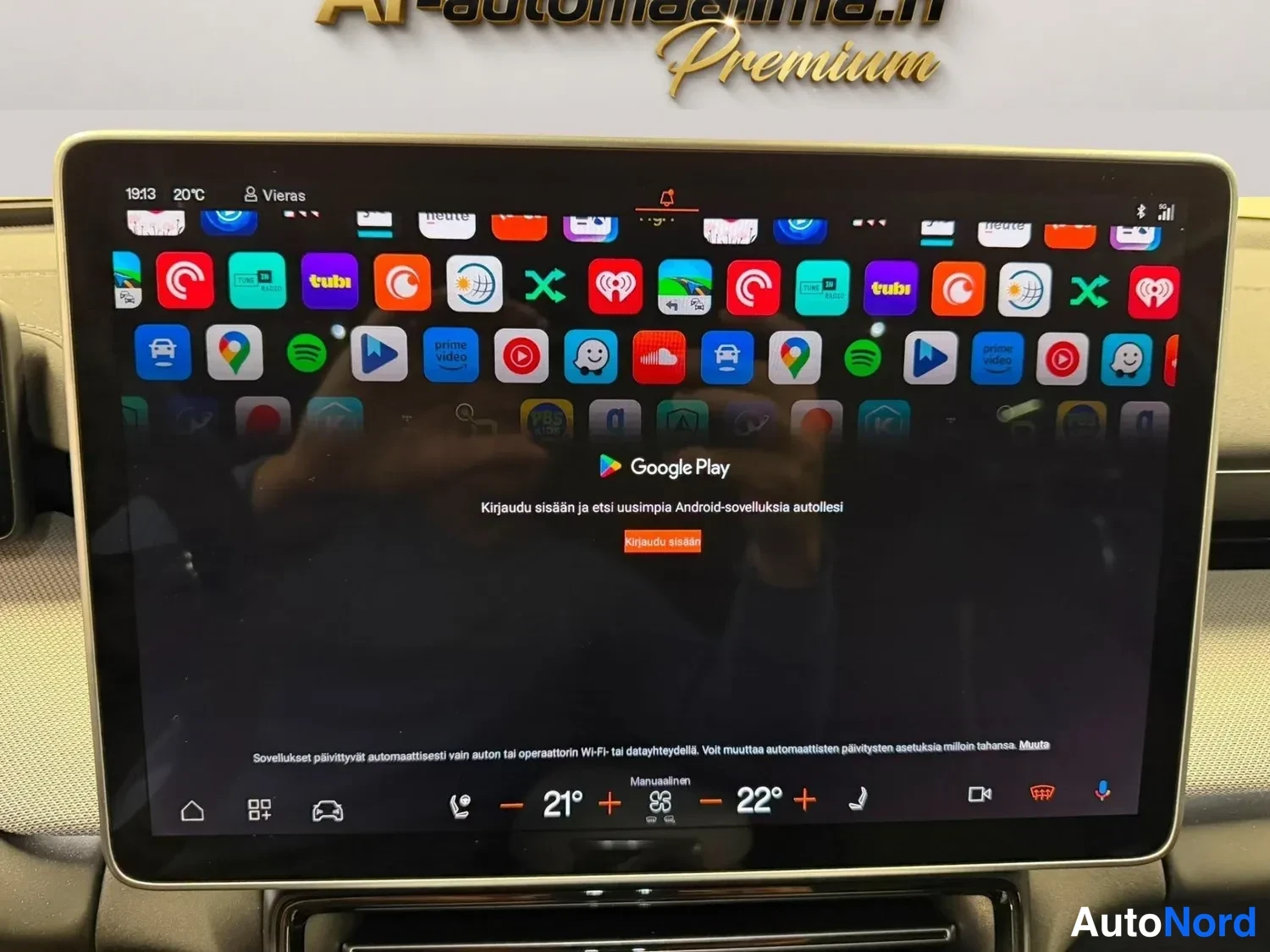 Muu: Auton infotainment-näyttö, jossa on Google Play -sovellus avattuna tekstillä Kirjaudu sisään ja etsi uusimpia Android-sovelluksia autollesi, taustalla sovellusk