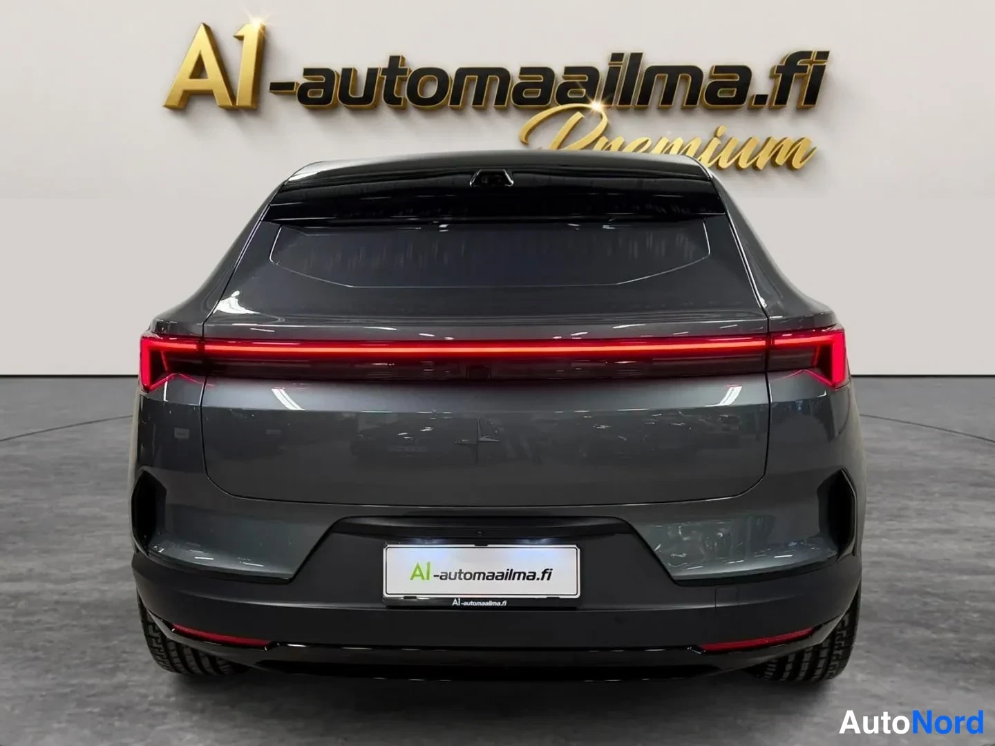 Takaa: Auton takaosa suoraan takaa: täysleveä punainen takavalo, tummanharmaa kori ja A1-automaailma.fi -kyltti rekisterikilven paikalla.