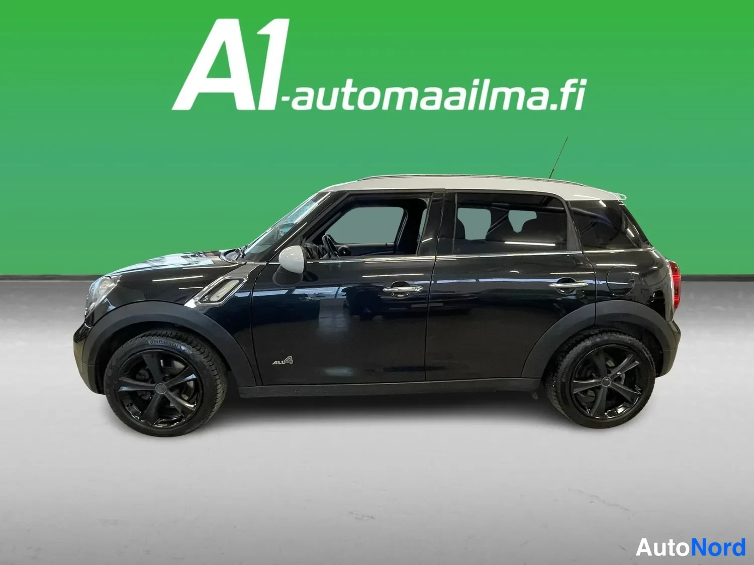 Takaviisto: Musta henkilöauto sivusuunnasta oikealta kuvattuna, valkoinen katto, mustat kevytmetallivanteet ja tunnelmavalo oven alaossa.