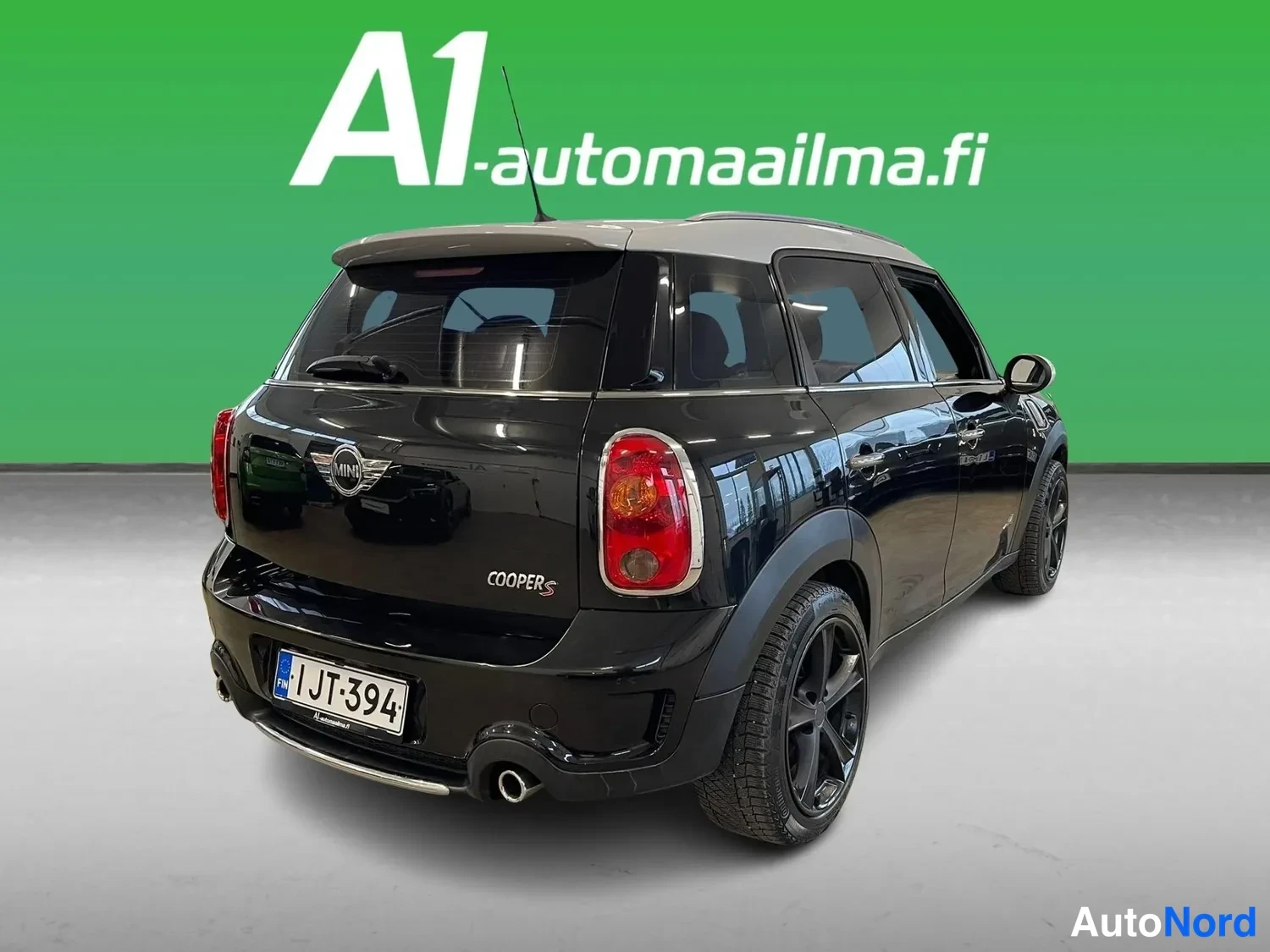 Takaviisto: Mustan Mini Countrymanin takakulmanäkyvä takapää ja oikea sivu, rekisterikilpi.