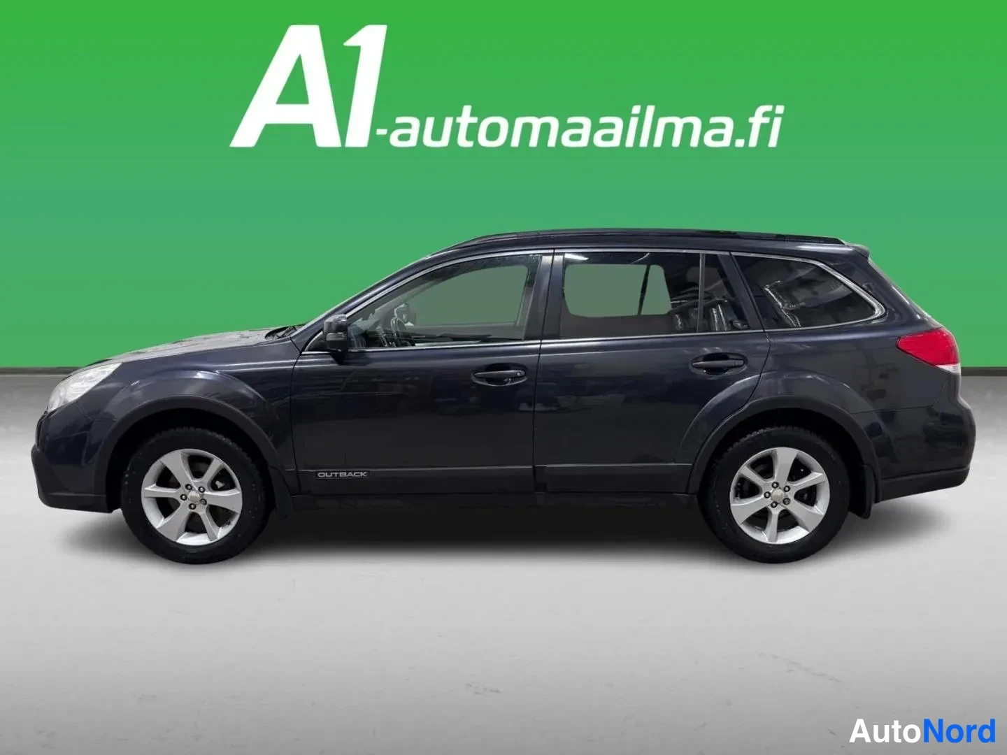 Etuviisto, nokka vasemmalle: Auton kuljettajan puolen sivukulma: tummanharmaa farmarivalokkuus koko autona kuvattuna, etuosa kuvan vasemmassa reunassa, hopeanväriset kevytmetalliva