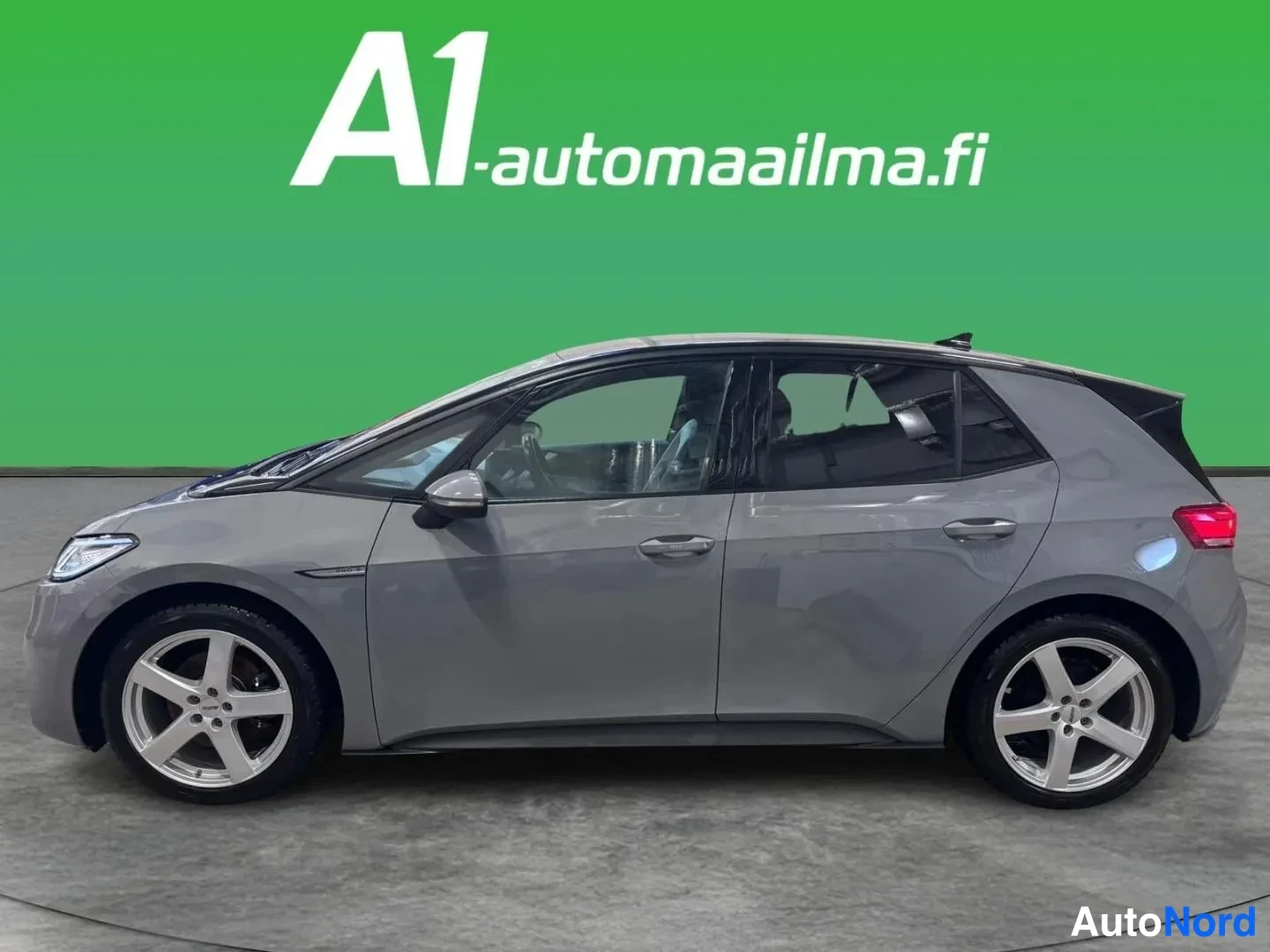 Sivulta: Harmaa Volkswagen ID.3 -henkilöauto sivusta vasemmalle kuvattuna studio­taustalla, hopeat viisipaltaiset vanteet.
