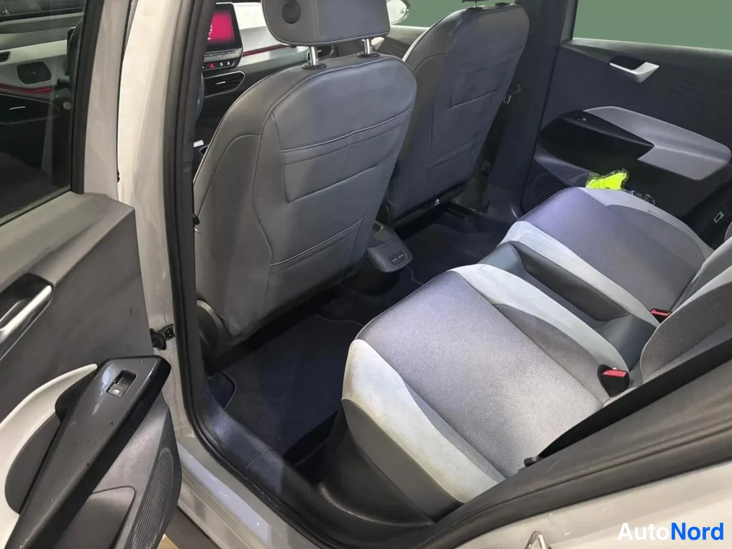 Takaa: Volkswagen ID.3:n takasäili avattu: harmaa tavaratilanäyttö, mustat lattiamatot ja harmaat kangaspenkit.