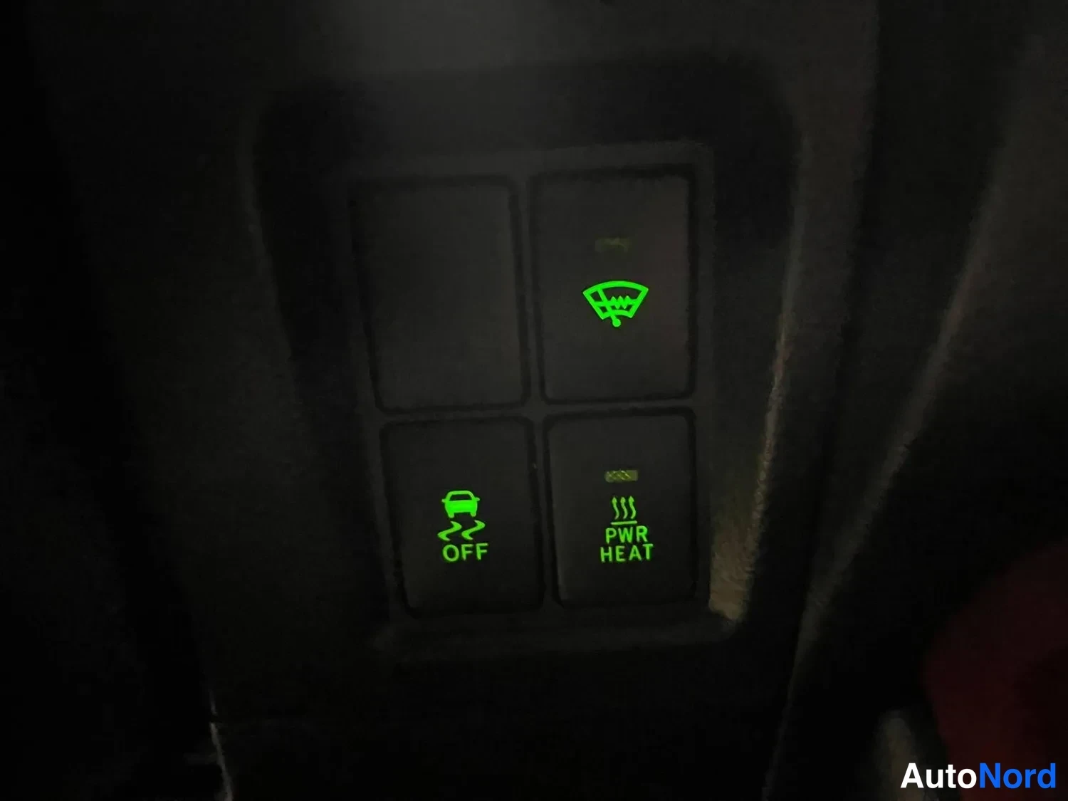 Muu: Sisävalitsinpötkö pimeässä: vihreällä valaistut kytkimet, joissa merkinnät OFF (talliauto/luistonesto-ikoni), PWR HEAT ja tuulilasin lämpökuvio.
