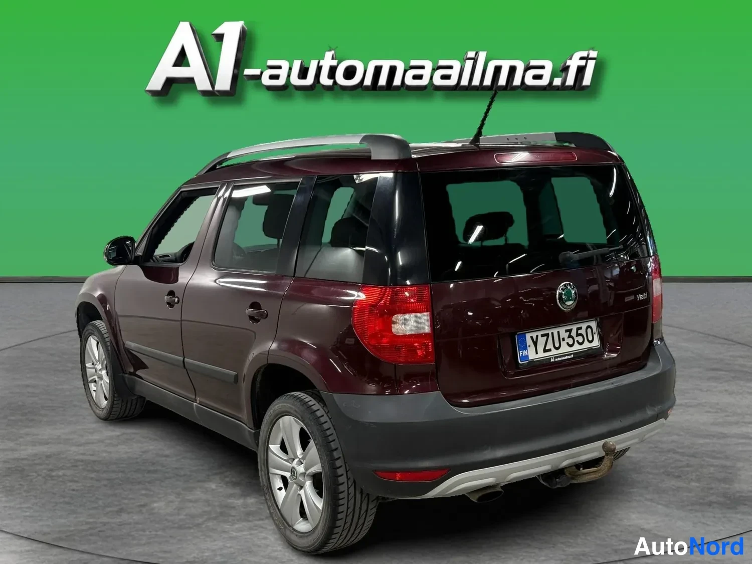 Takaviisto: Tummanpunaisen Skoda Yetin takaosakulmanäkymä oikealta: takavalo, -kilpi, vetoaisa ja hopeiset kattokaiteet näkyvät.