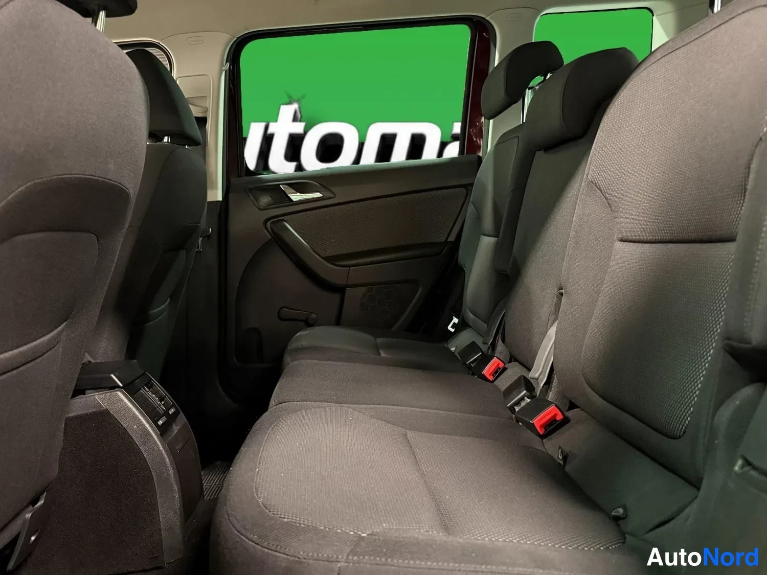 Sivulta: Skoda Yetin takapenkki ja takiovi sisältä: tummat tekstiilipenkit, ovineloste ja vyöharjat näkyvät.