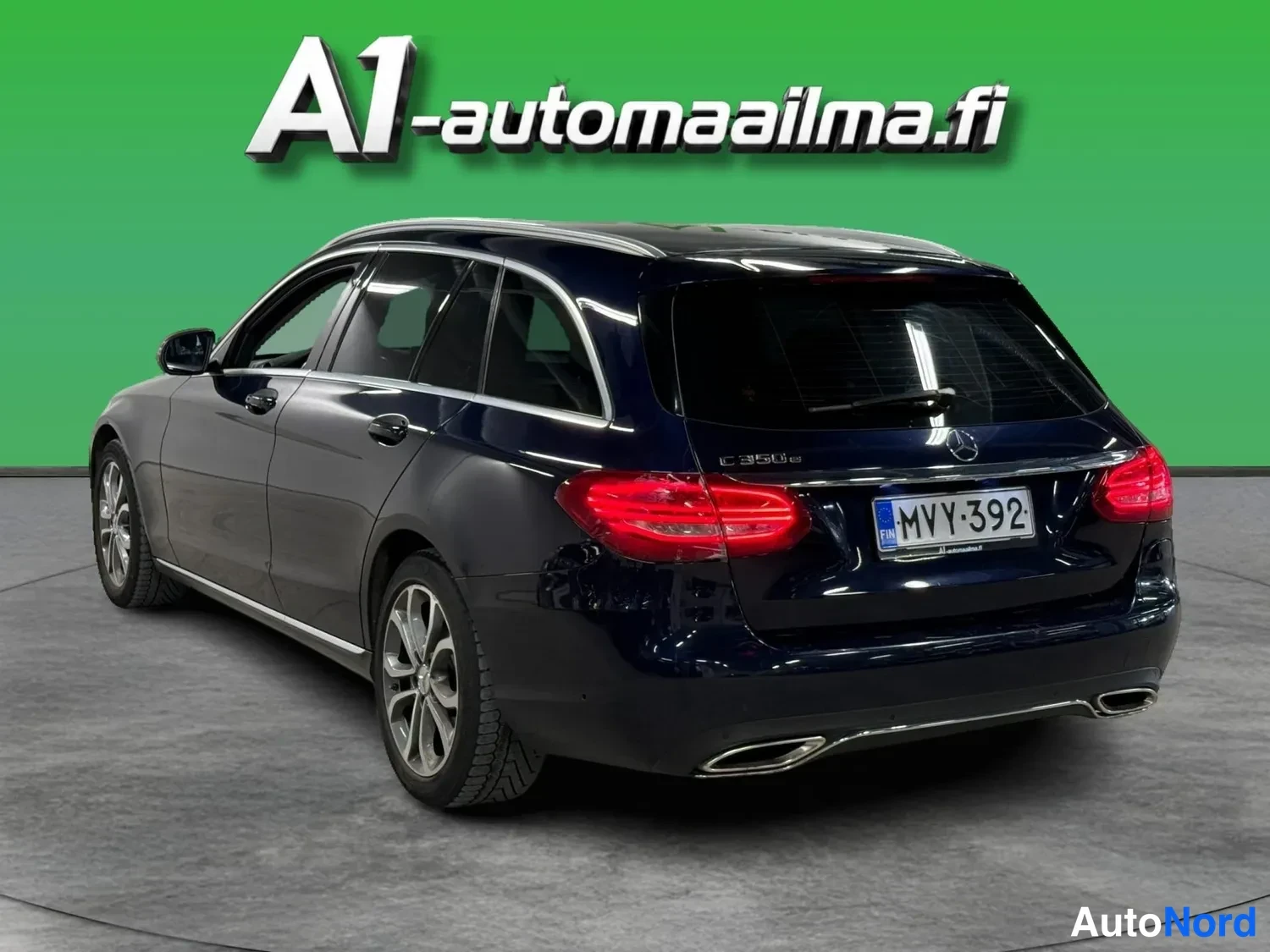 Takaviisto: Tummansininen Mercedes-Benz farmari takaa kolme neljännestä; takavalojen punainen muotoilu, neljä pakoputkea, rekisterikilpi.