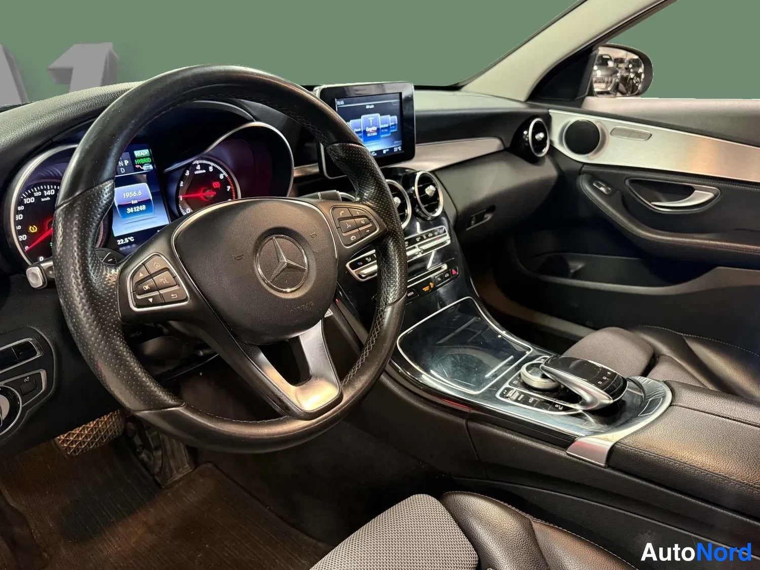 Sivulta: Kuljettajan näkymä: Mercedes-Benzin ohjauspyörä ja kojelauta, mittaristo ja media näyttö, ajoneuvon 341240 km lukema näkyvissä.