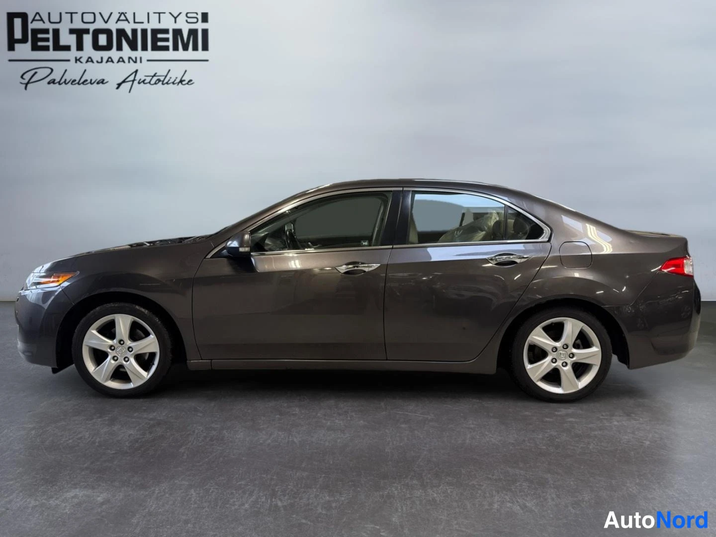 Sivulta: Harmaanruskea Honda Accord -sedani sivusta otettuna kuvana sisätiloissa.