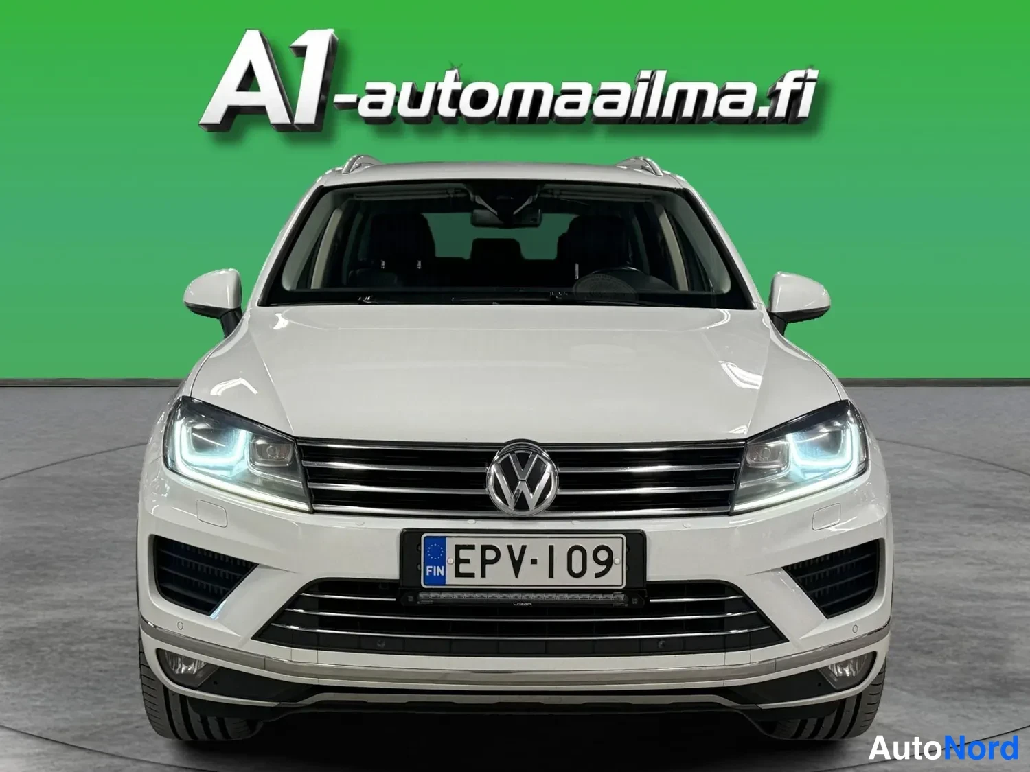 Edestä: Valkoinen Volkswagen Touareg suoraan edestä, rekisteritunnus.