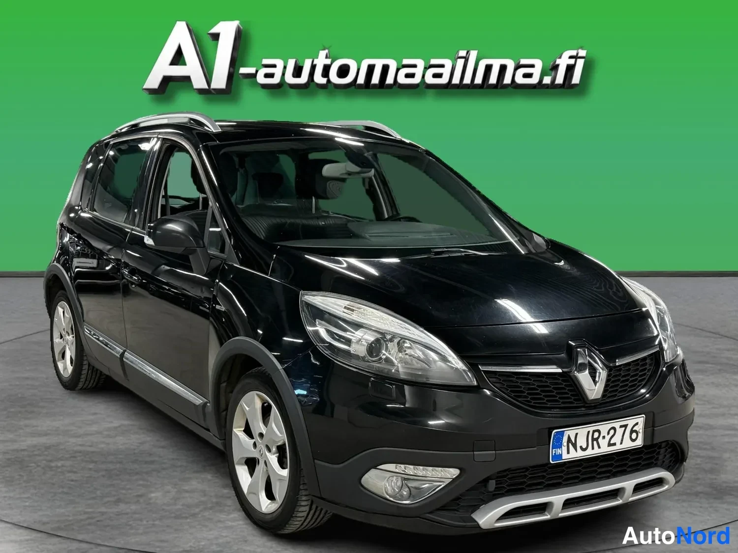 Etuviisto, nokka oikealle: Mustan Renault Scenicin etukolmisasukuva, keula ja vasen kylki näkyvissä.
