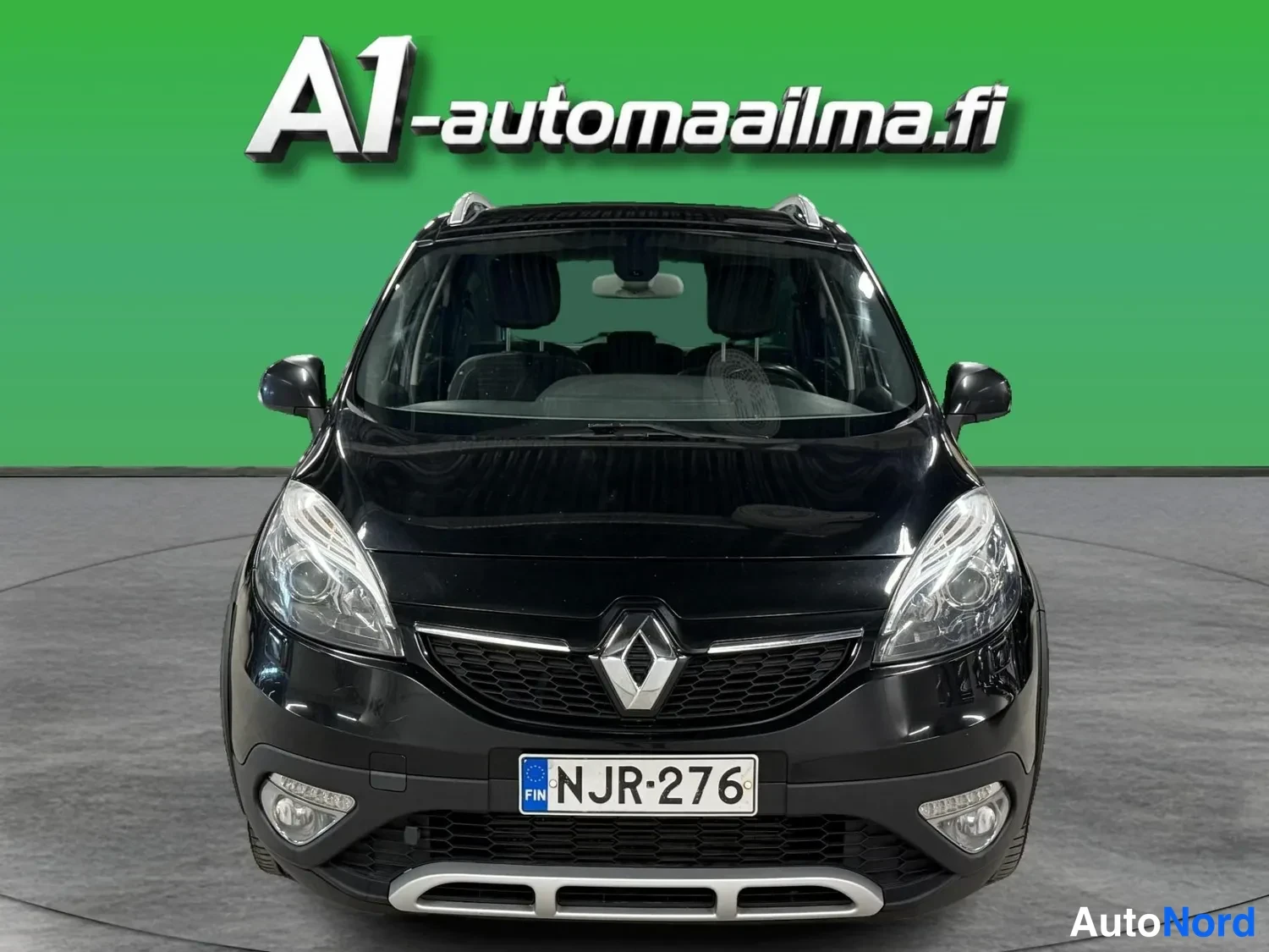 Edestä: Mustan Renault Scenicin suora etukuva.