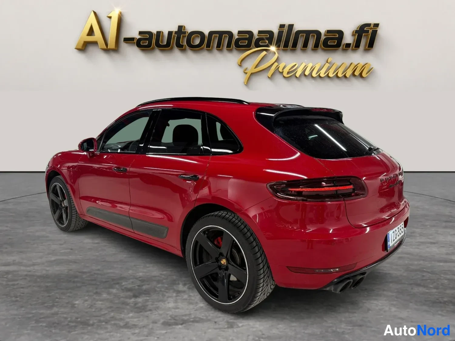 Takaviisto: Punainen Porsche Macan SUV takaviistossa vasemmalta, näkyvissä takavalot, takapuskuri ja neljä pakoputkea.