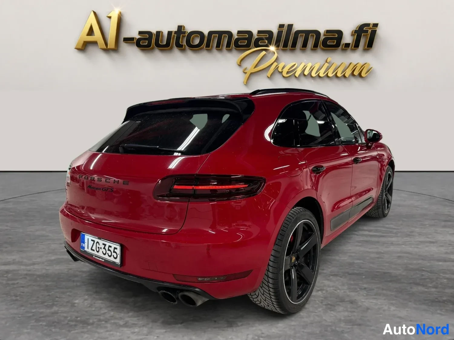 Takaviisto: Punainen Porsche Macan SUV takaviistossa vasemmalta, näkyvissä takavalot, rekisterikilpi ja mustat pyörät.