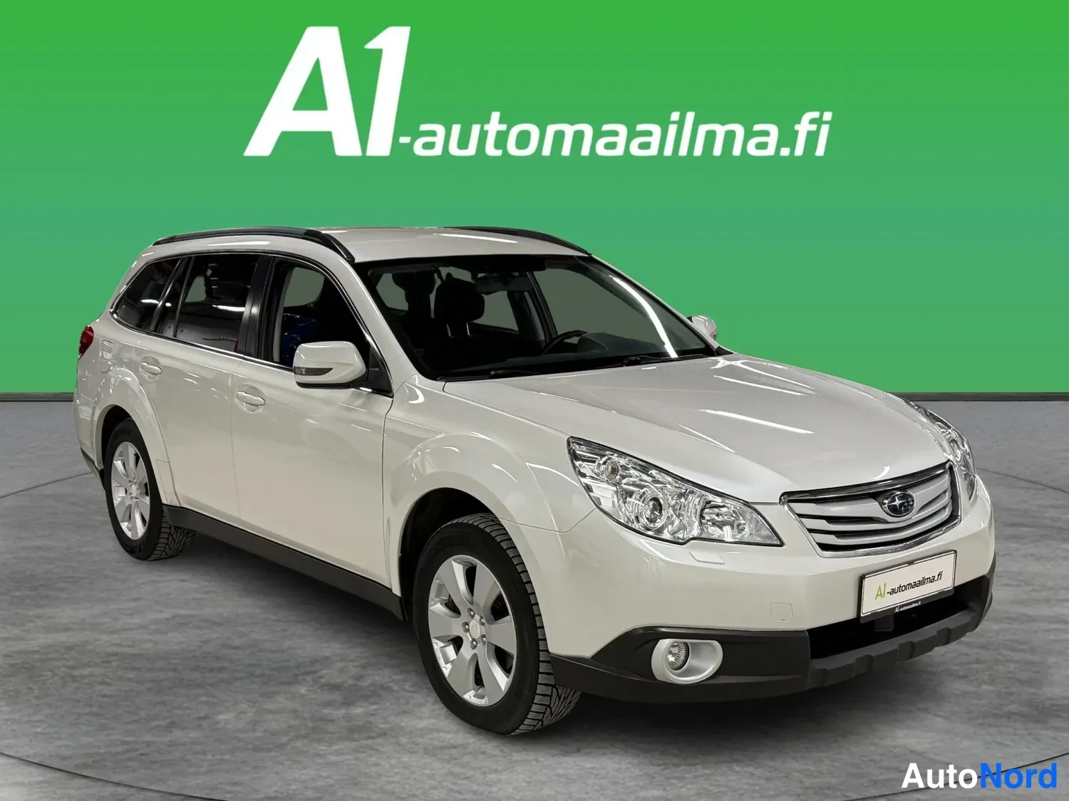 Etuviisto, nokka oikealle: Subaru Outback -farmari etuosaltaan ja oikean sivulleen näkyvästi valokuvattu, valkoinen kori, studiotrkTausta.