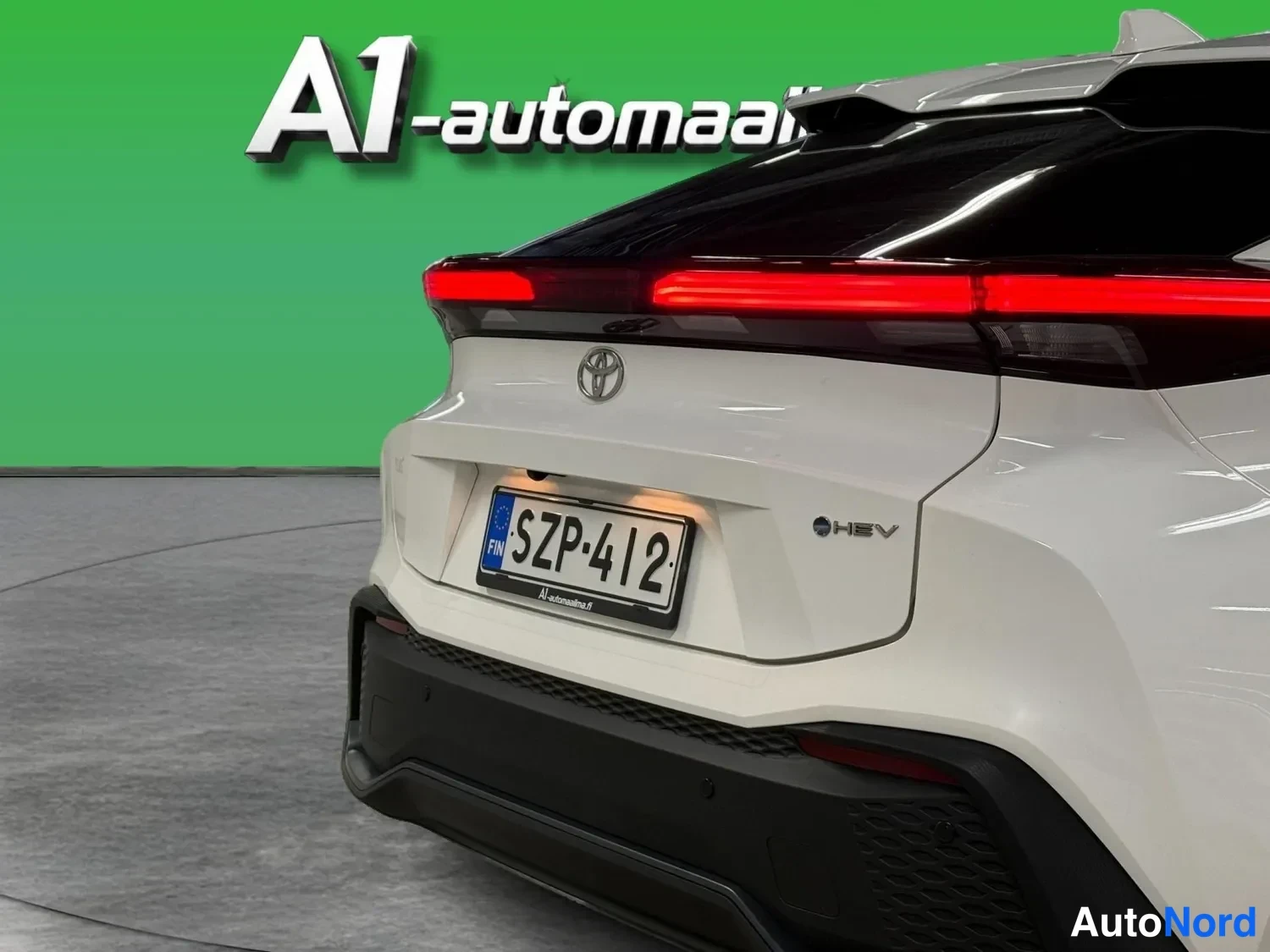 Takaa: Lähikuva valkoisen Toyota C-HR:n takapäästä; punainen takavalonauha, Toyota-merkki ja rekisterikilpi ovat terävinä.