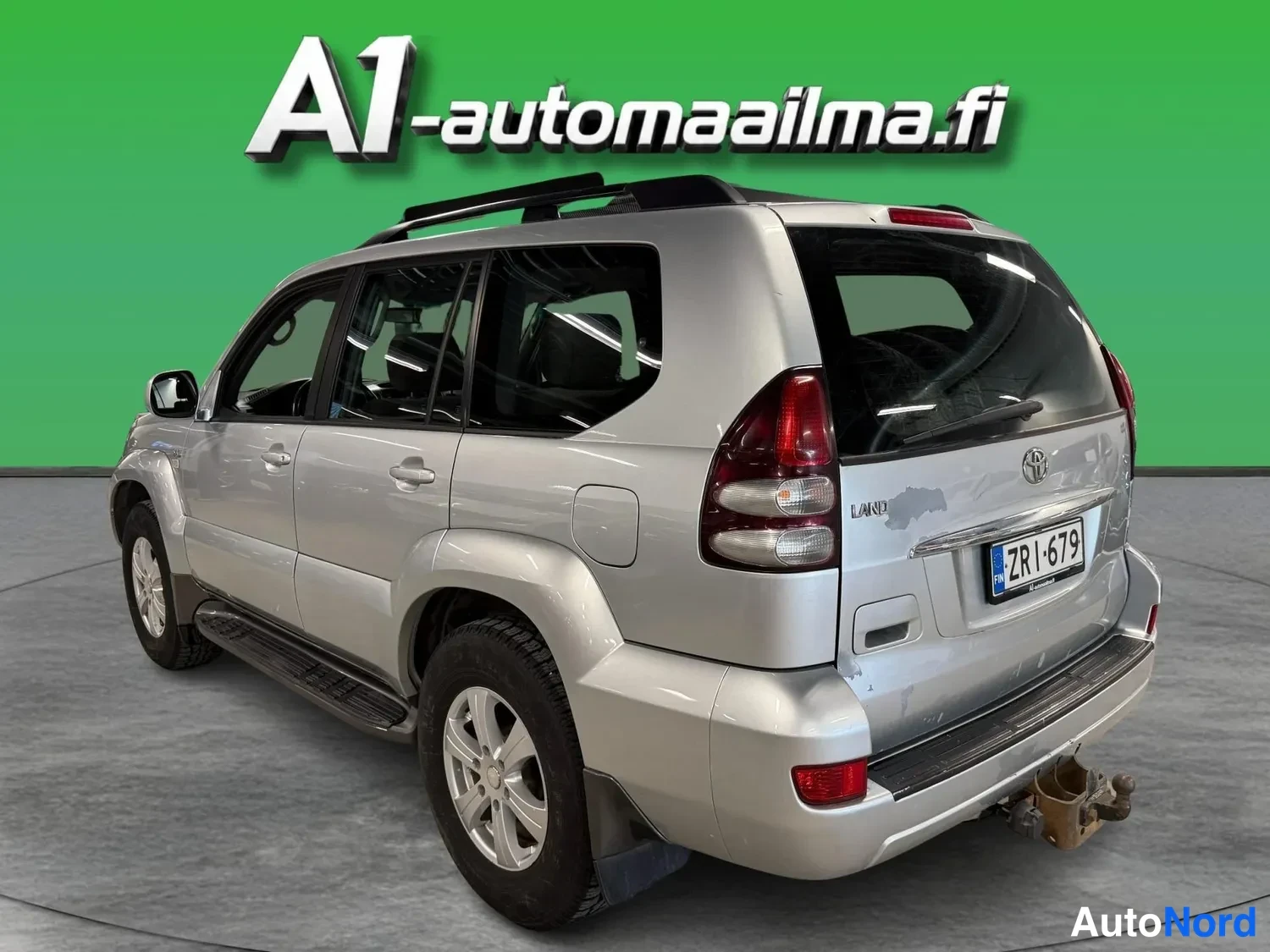 Takaviisto: Takakulmakuvassa hopeanvärinen Toyota Land Cruiser, takavalot, tavaratilan luukku ja rekisterikilpi näkyvät.