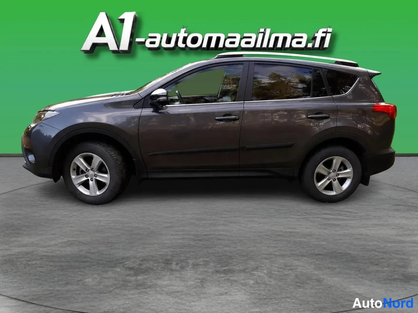 Sivulta: Tummanruskea Toyota RAV4 sivusta vasemmalta, kattokaiteet, hopeavanteet ja peilin kiiltävät kannet näkyvissä.