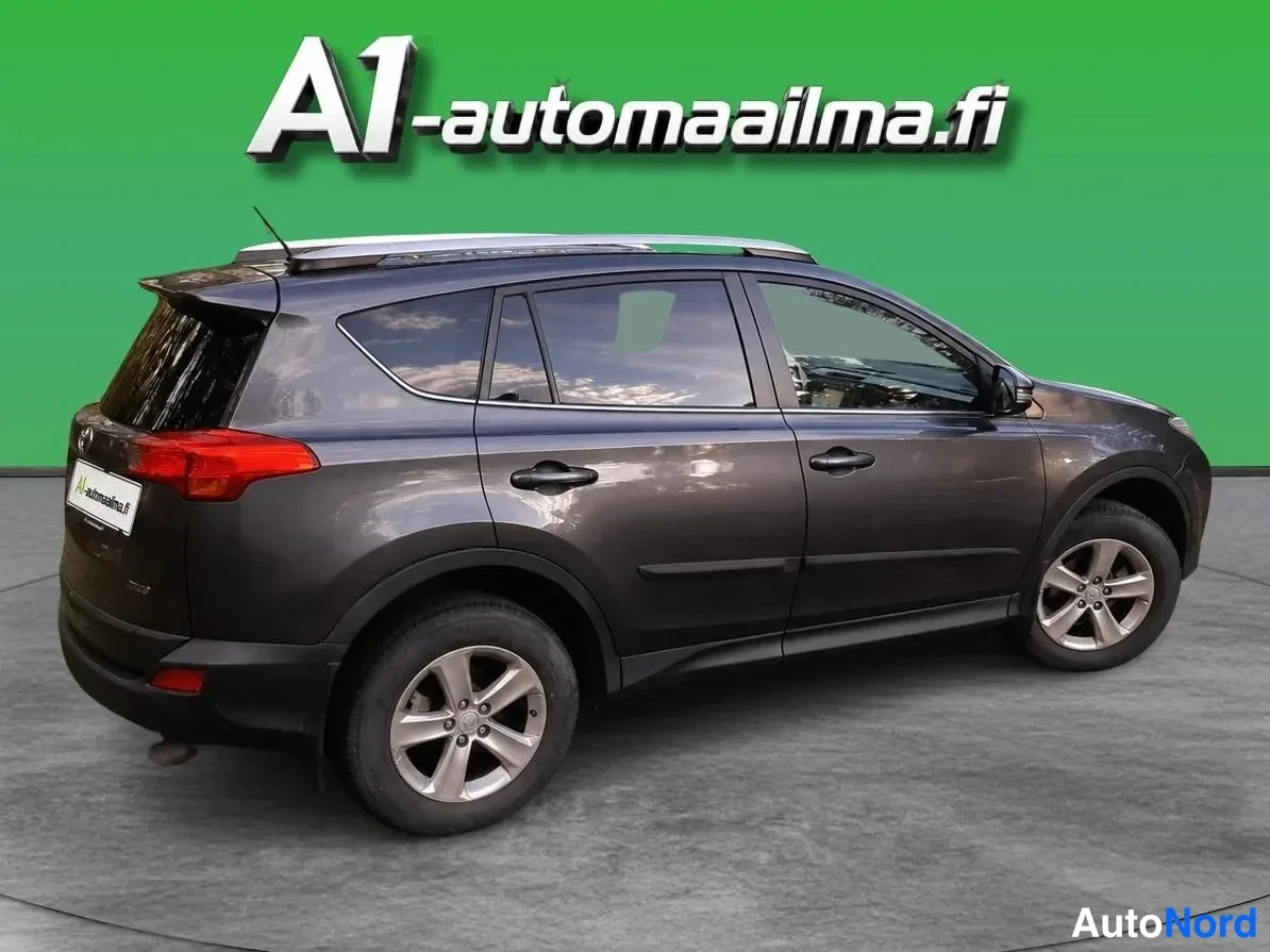 Takaviisto: Tummanharmaan Toyotan takakulmanäyttö: takapää ja vasen kylki näkyvissä, katolla krominväriset kaiteet.