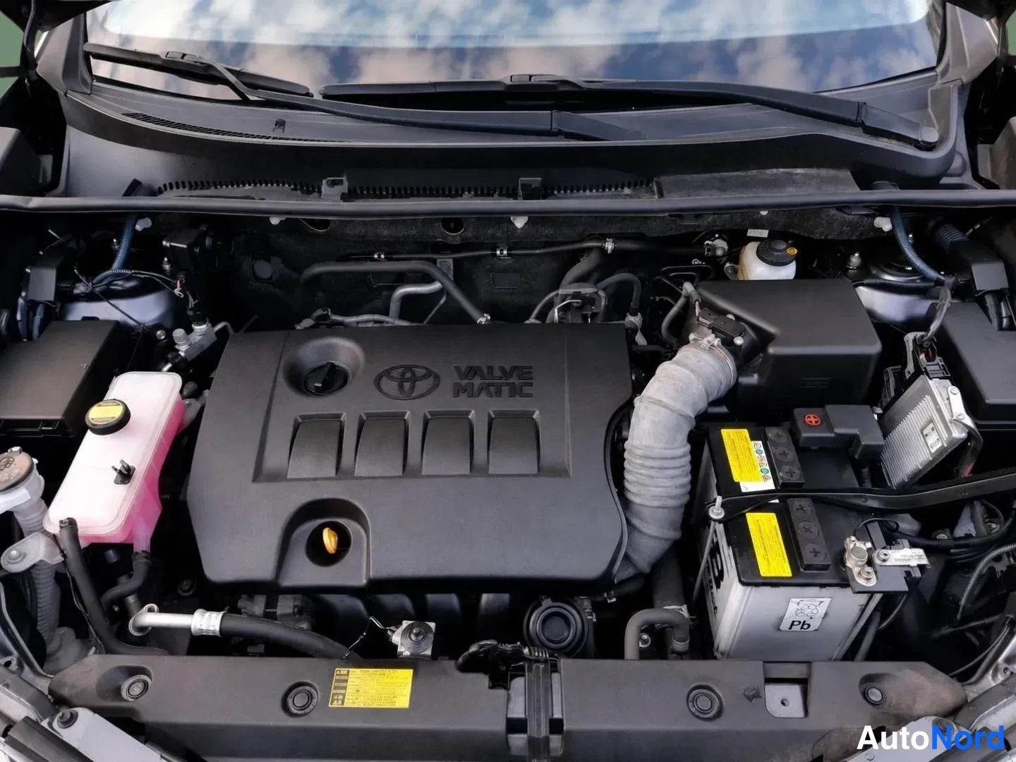 Edestä: Toyotan VALVE MATIC -merkitty moottorin suojus, akku ja jäähdytinnesteainesäiliö.