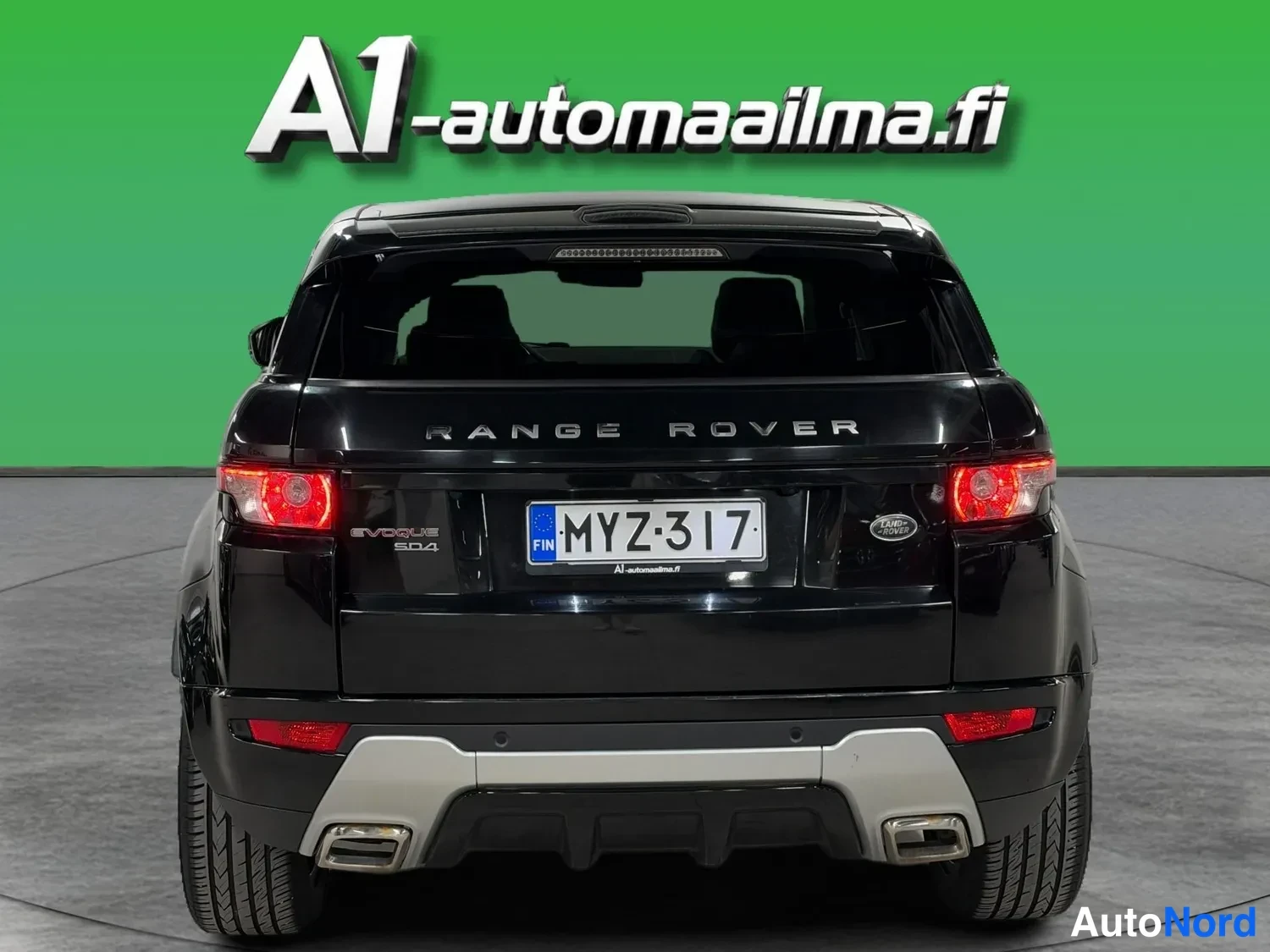 Takaa: Musta Range Rover Evoque takaa kuvattuna, rekisteritunnus, harmaa alakori ja kaksi pakoputkea.