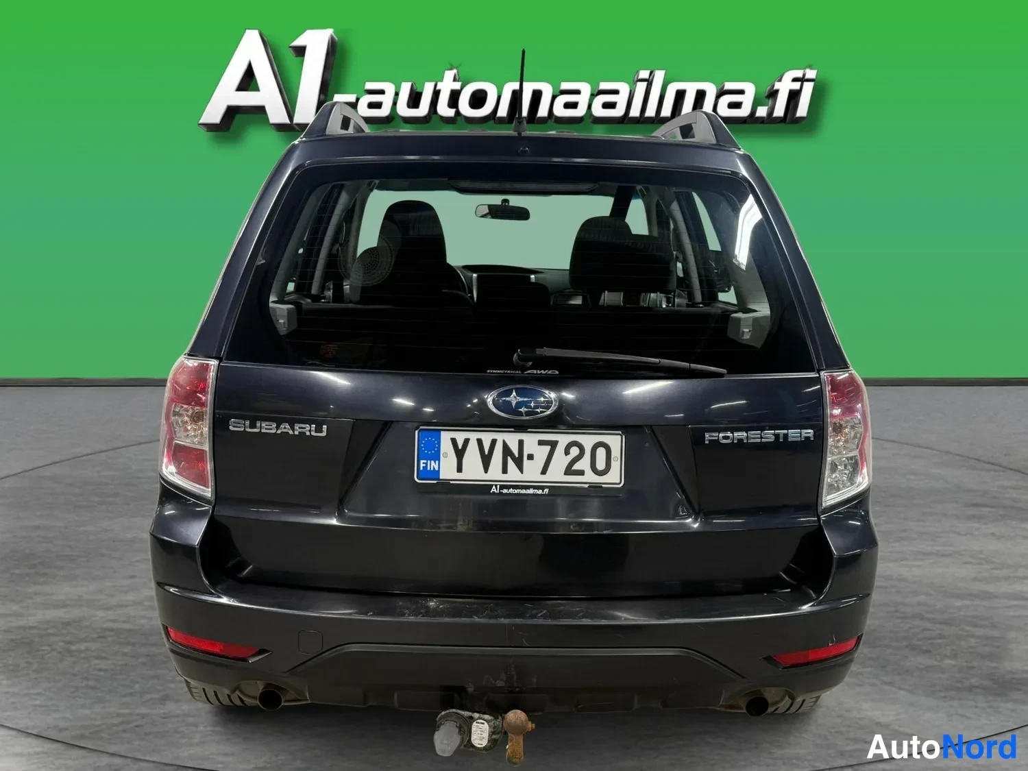 Takaa: Subarun takaosa suoraan takaa: tumma korit, SUBARU- ja FORESTER-tekstit, rekisteritunnus ja takavaloja.