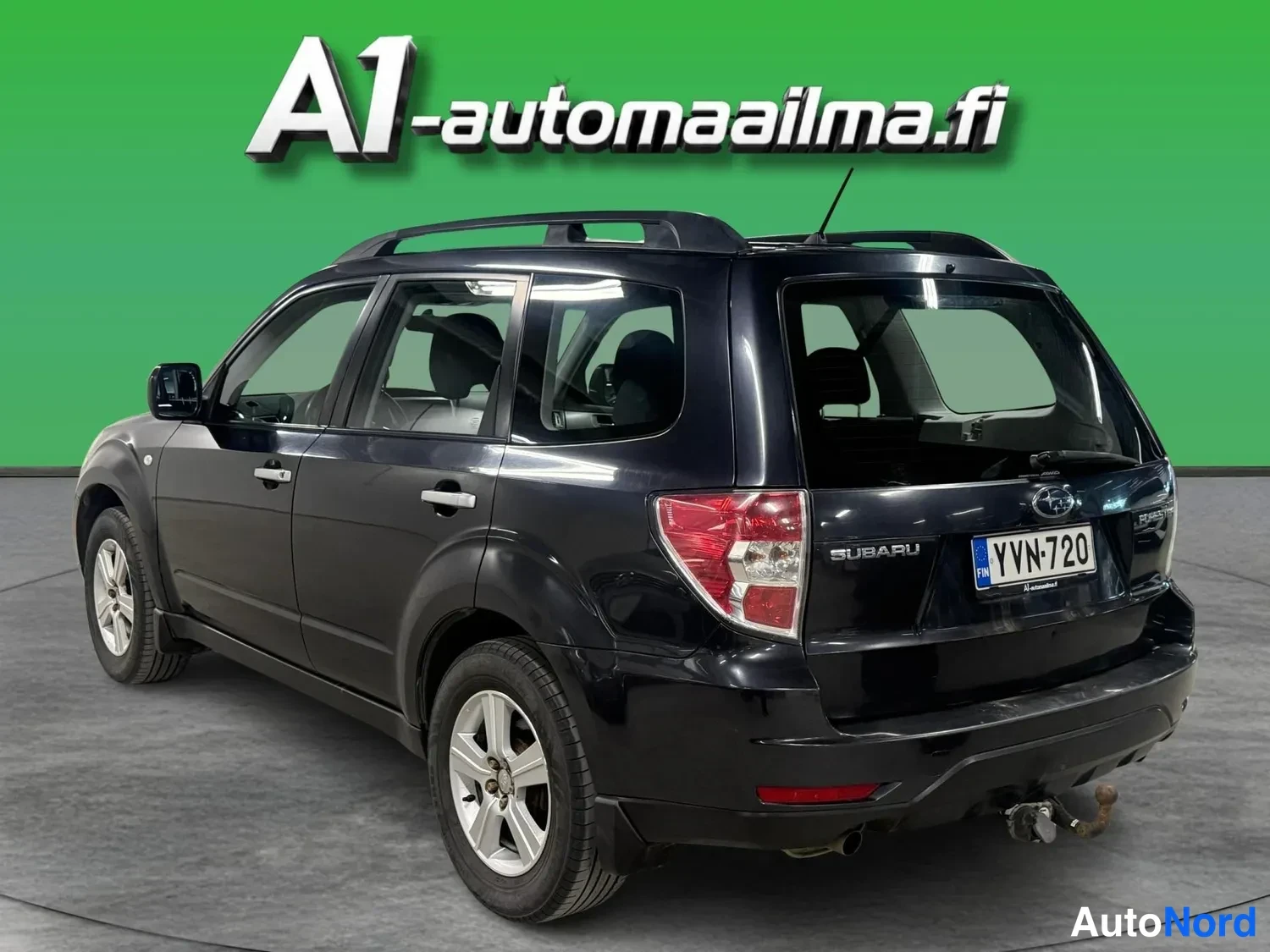 Takaviisto: Subaru kolmesta neljäsosasta takaa vasemmalta: tumma koriväri, kattokaiteet, rekisteritunnus ja takavalo.