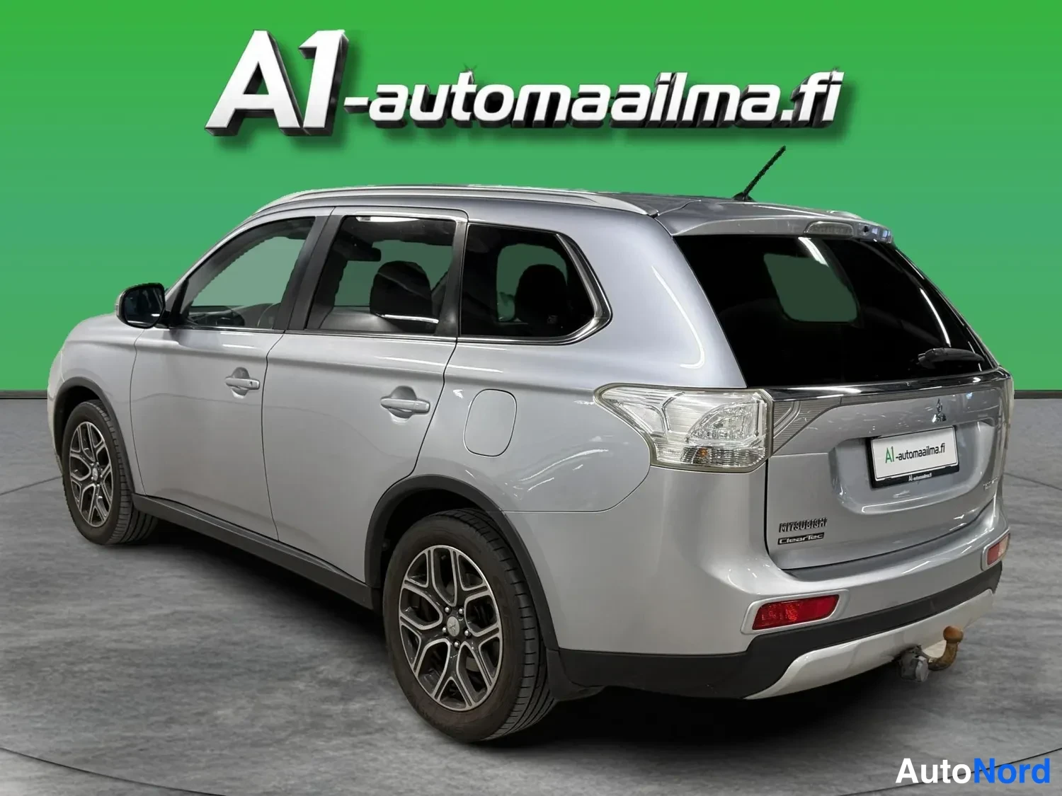 Takaviisto: Hopeanvärinen farmarimallinen auto kolmannelta takakulmalta kuvattuna, oikea kylki ja takapää näkyvissä, kevytmetallivanteet ja kattokaiteet.